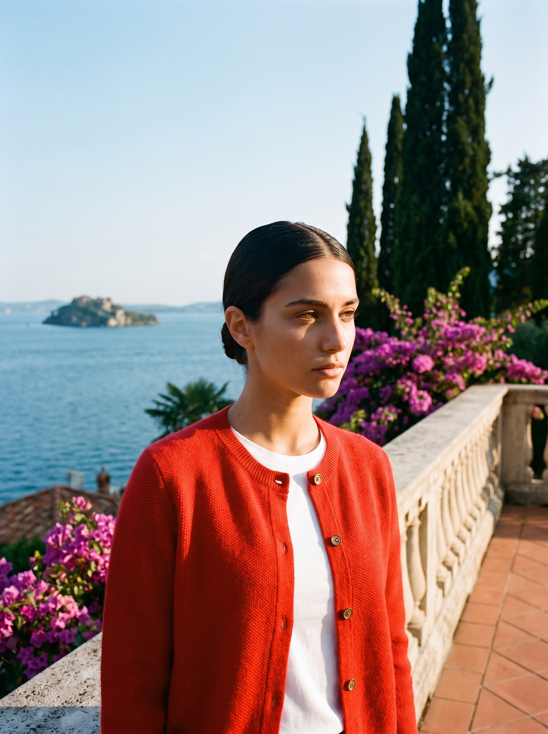 Woman wearing a red wool-blend cardigan on a terrace overlooking Lake Como, old money style — Aveloire