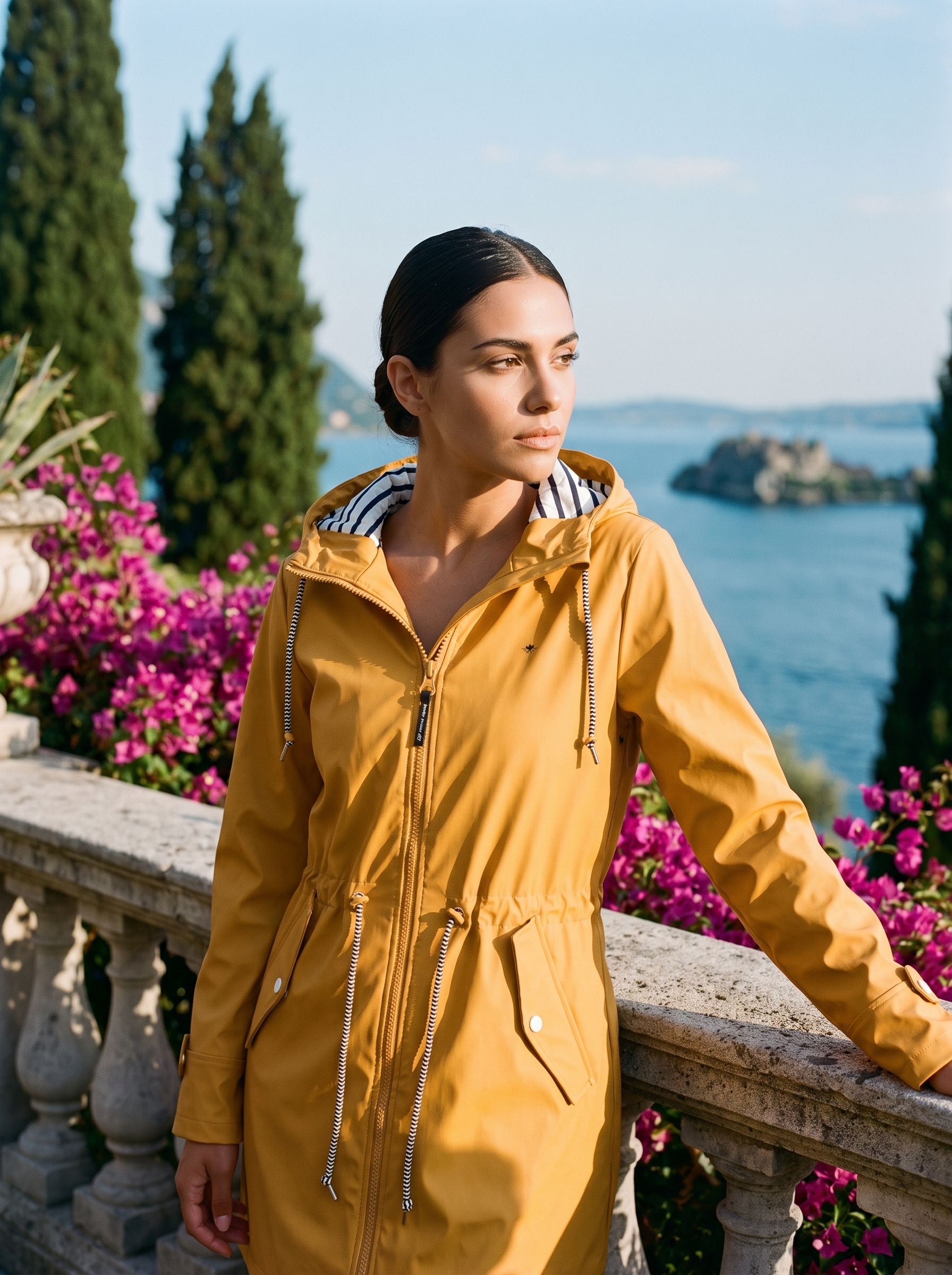 Woman wearing yellow waterproof jacket on a Lake Como terrace — Aveloire