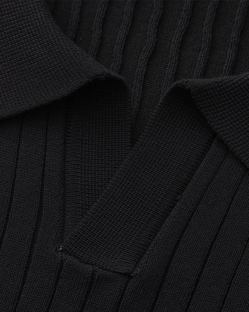 Close-up of a black pleated garment with a collar