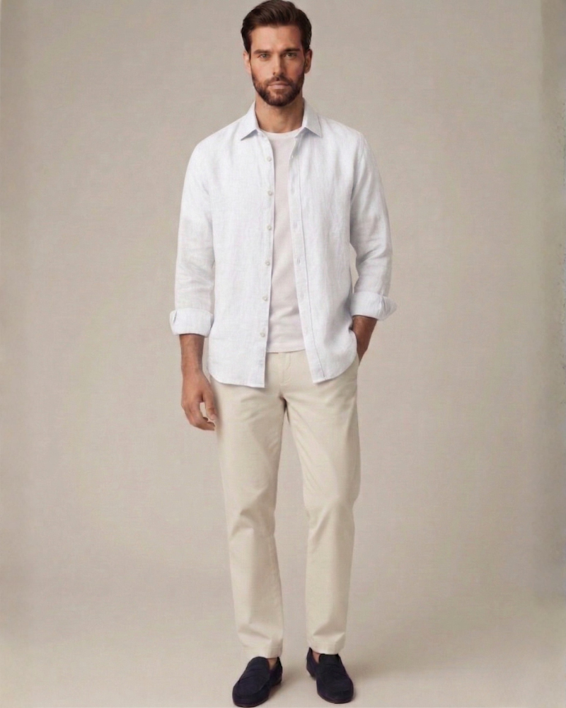 Male model wearing a white linen button-up shirt in a refined summer outfit
