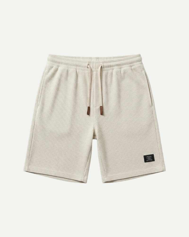 Beige shorts with a small logo on a white background
