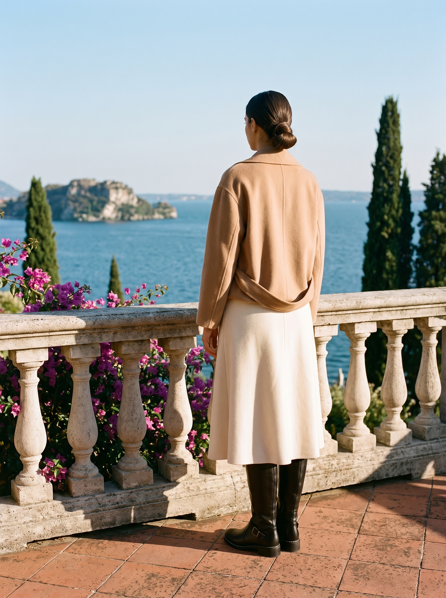Back view of black buckled riding knee high boots showing the stacked heel on a Lake Como terrace — Aveloire