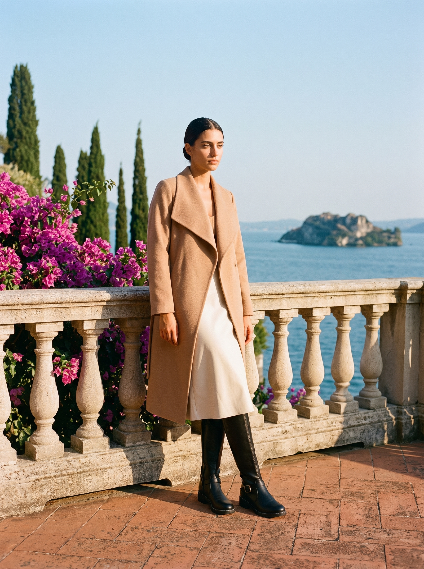 Full body front view of a woman in black buckled riding knee high boots on a Lake Como terrace — Aveloire