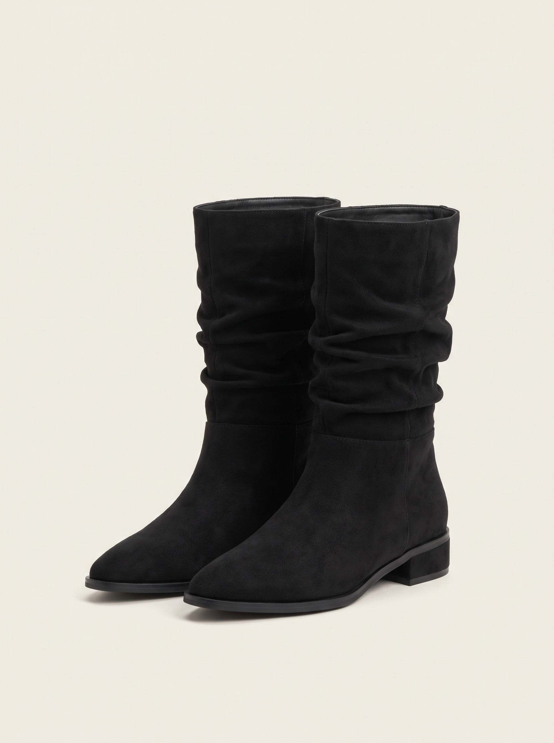 Pair of black suede-look slouch mid-calf boots on off-white background