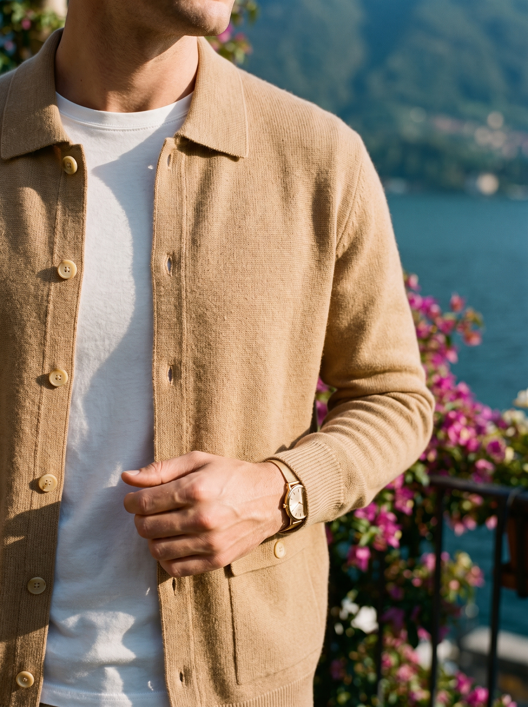 Shirt collar, horn-tone buttons and patch pocket detail of a camel cashmere cardigan — Aveloire