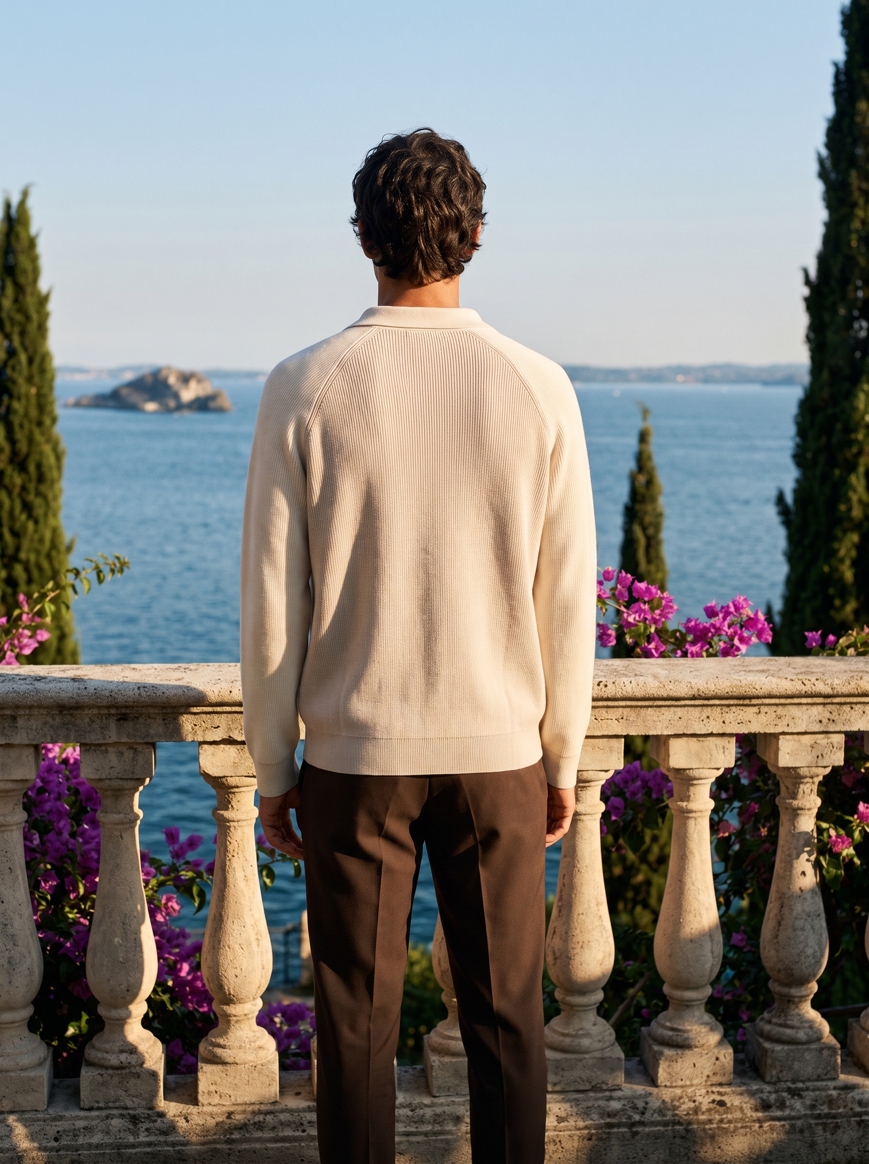 Back view of a cream two-tone half-zip knit polo sweater worn on a Mediterranean terrace — Aveloire