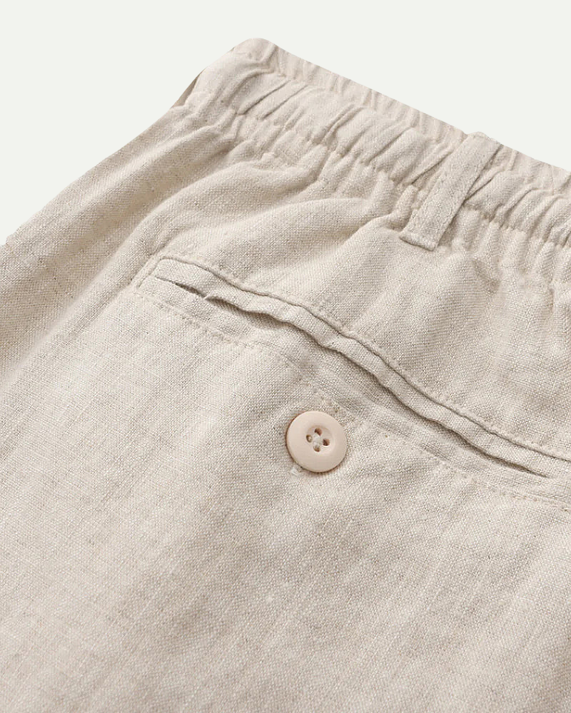 Close-up of beige pants with a button on a light background
