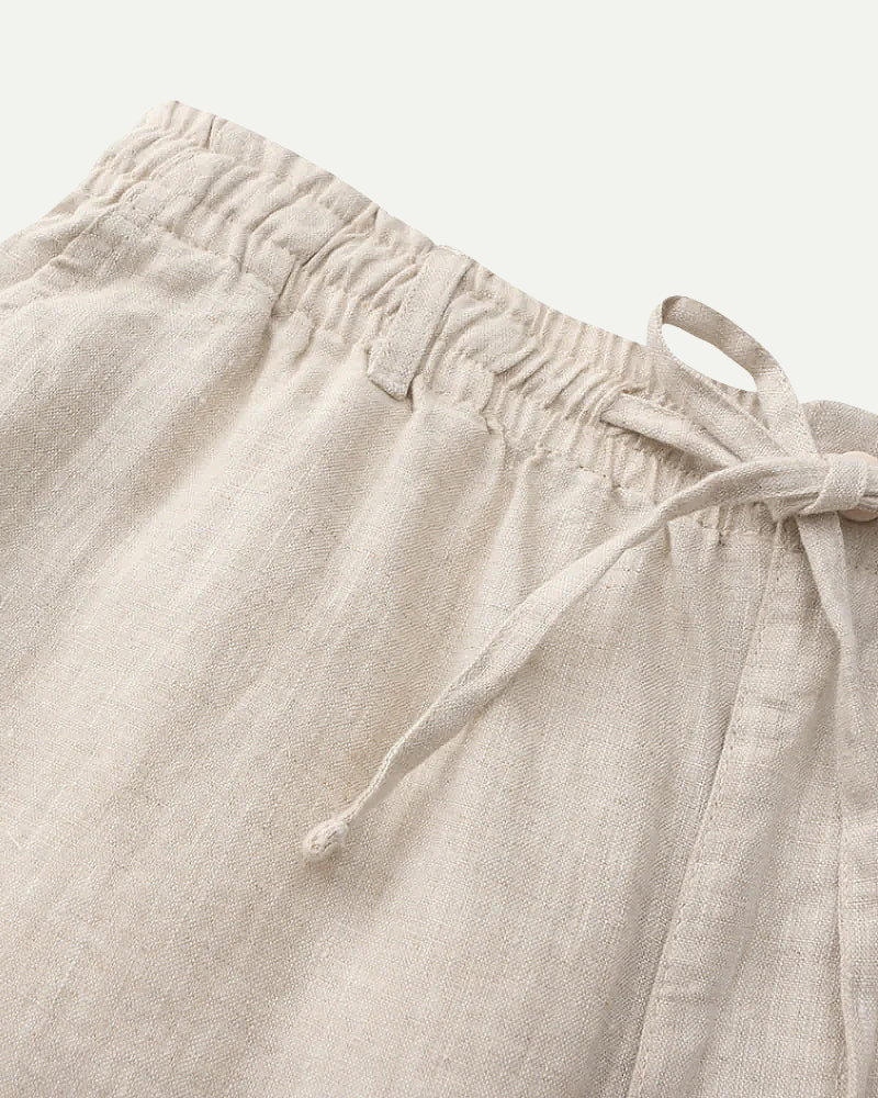 Beige linen pants with drawstring on a light background
