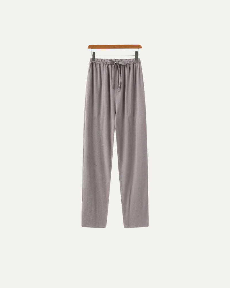 Gray linen pants on a hanger against a white background