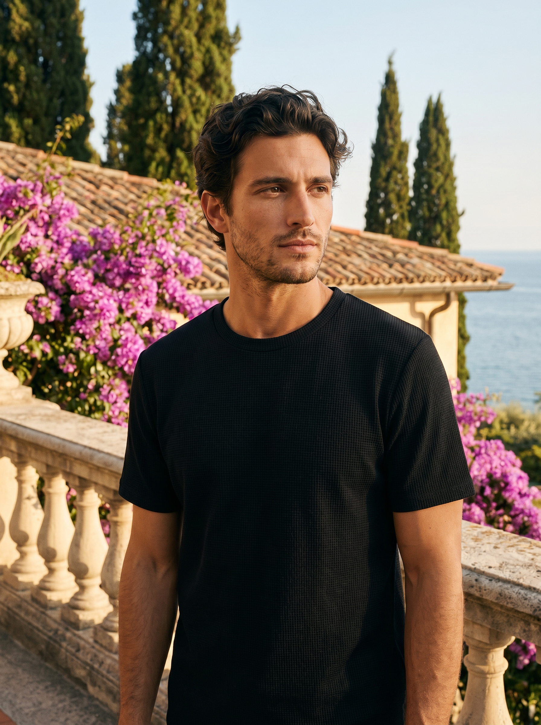 Man wearing a black waffle knit tee on a balcony overlooking Lake Como, old money style — Aveloire