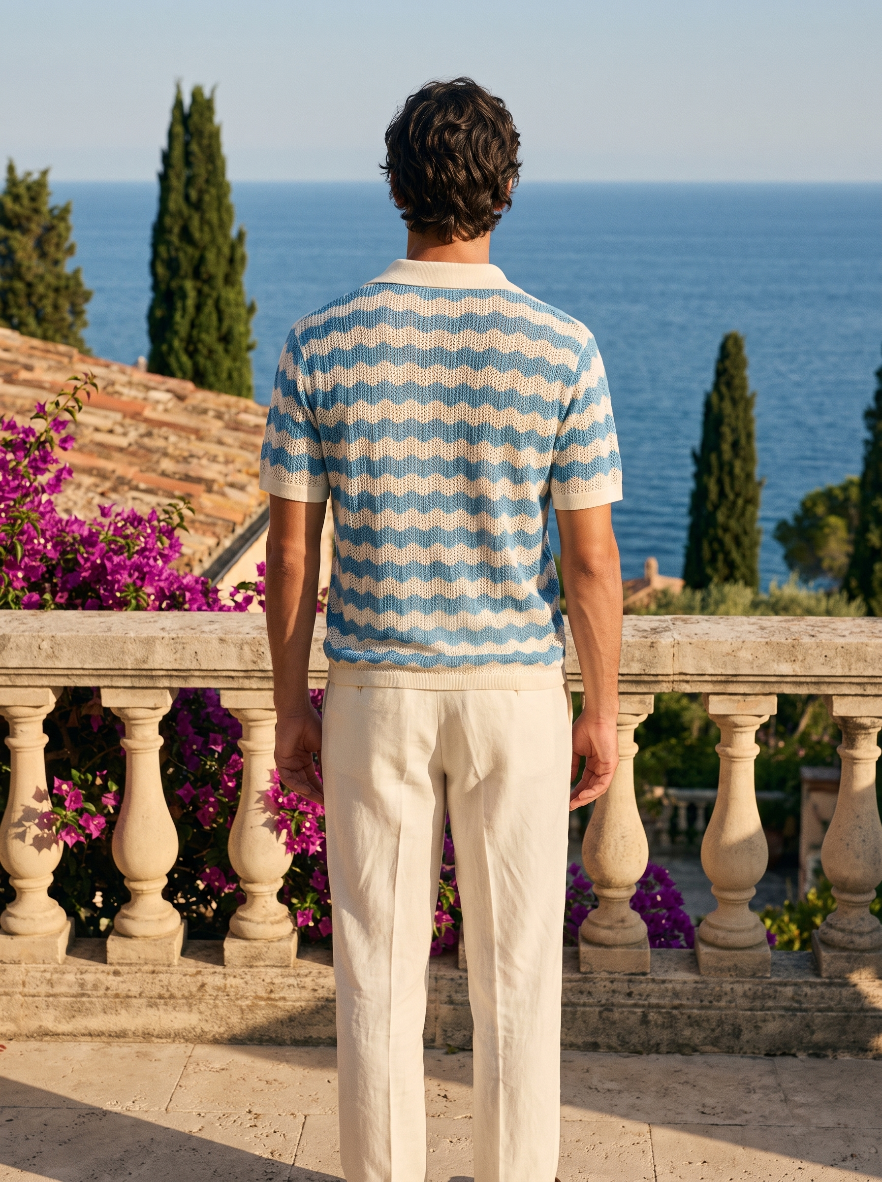 Back view of a man in a blue and cream wave knit button shirt overlooking Lake Como — Aveloire