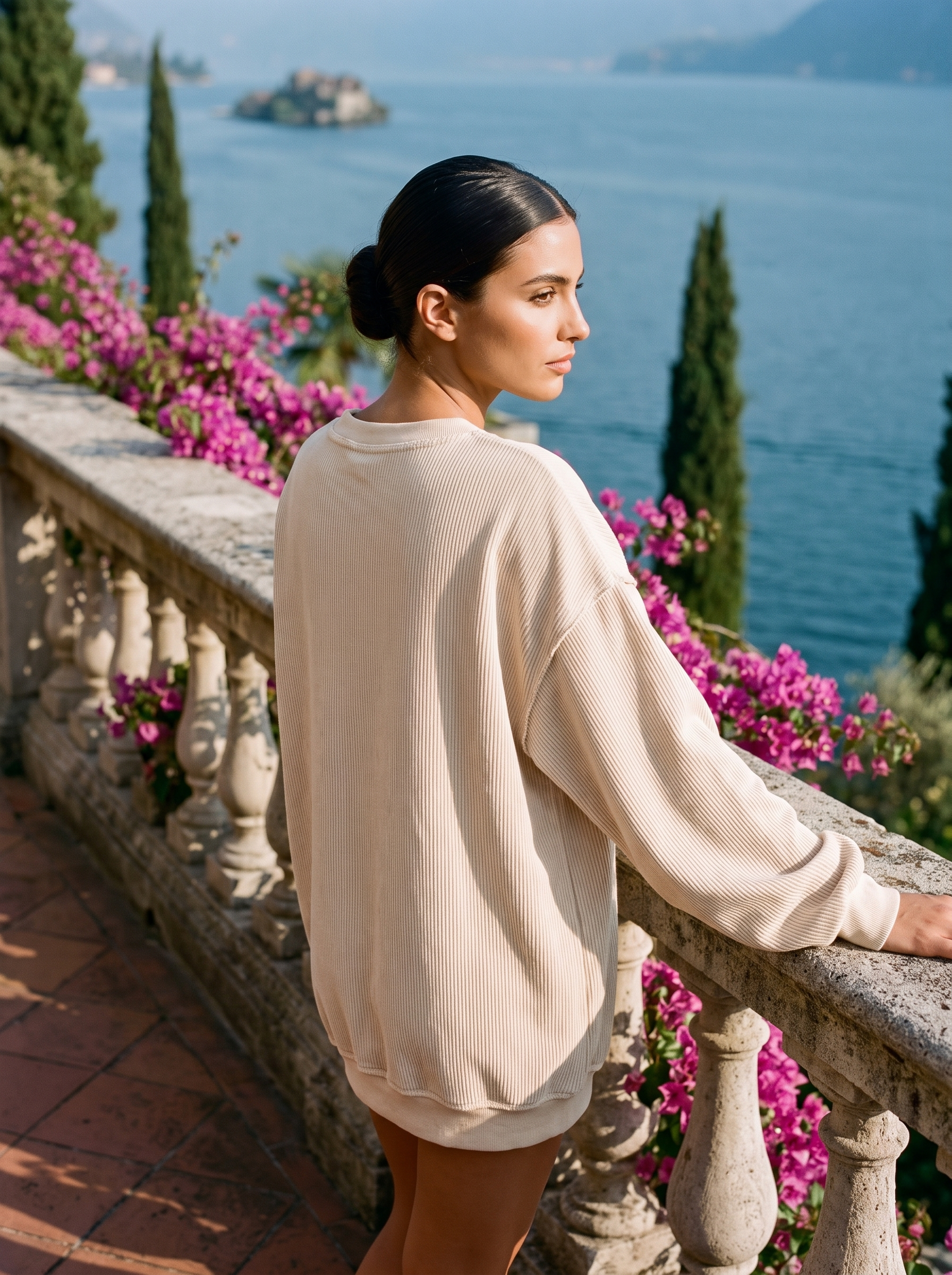 Back view of a cream corded oversized sweatshirt on a Lake Como terrace — Aveloire
