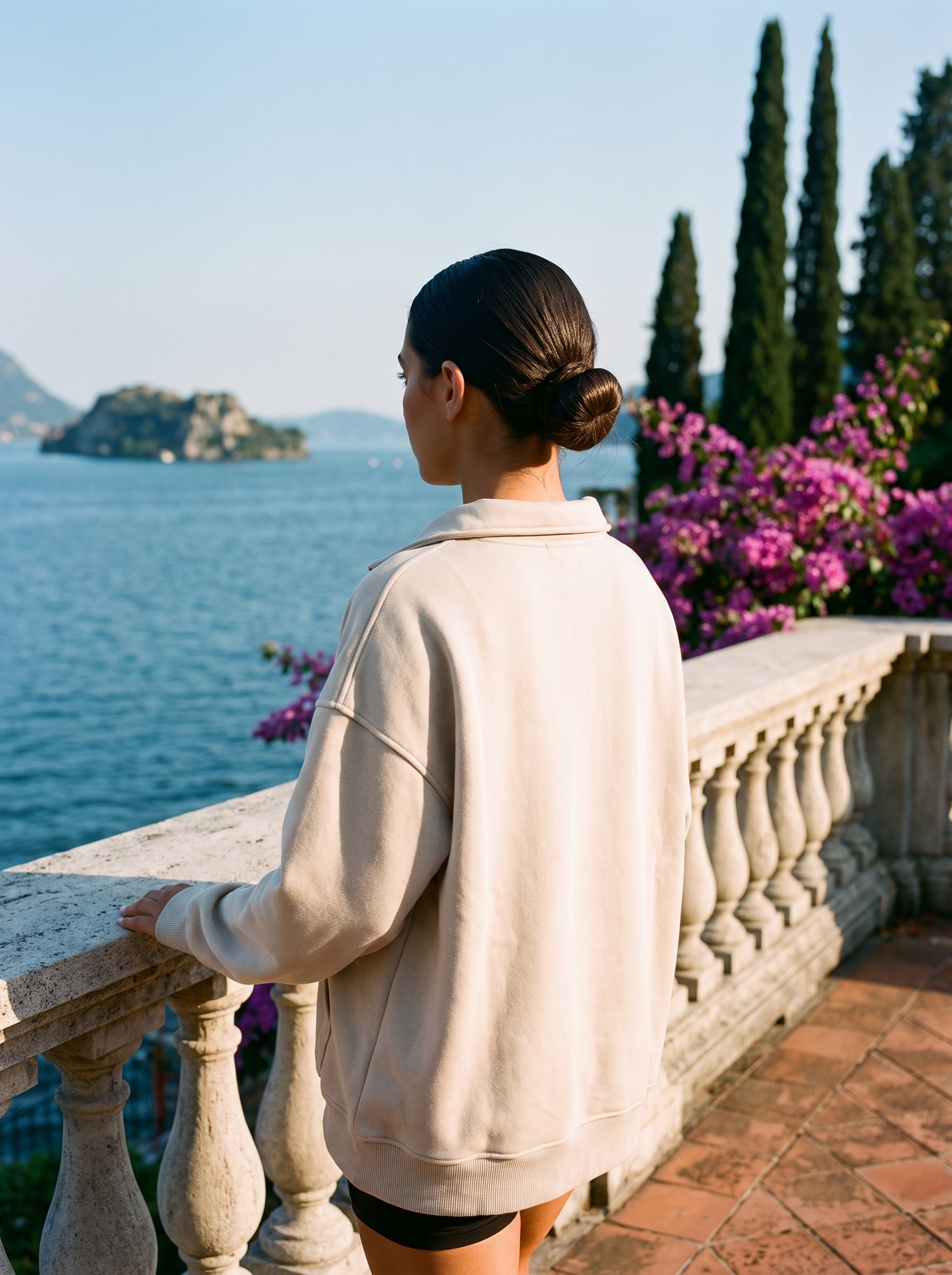 Back view of a beige oversized half-zip pocket sweatshirt on a Lake Como terrace — Aveloire