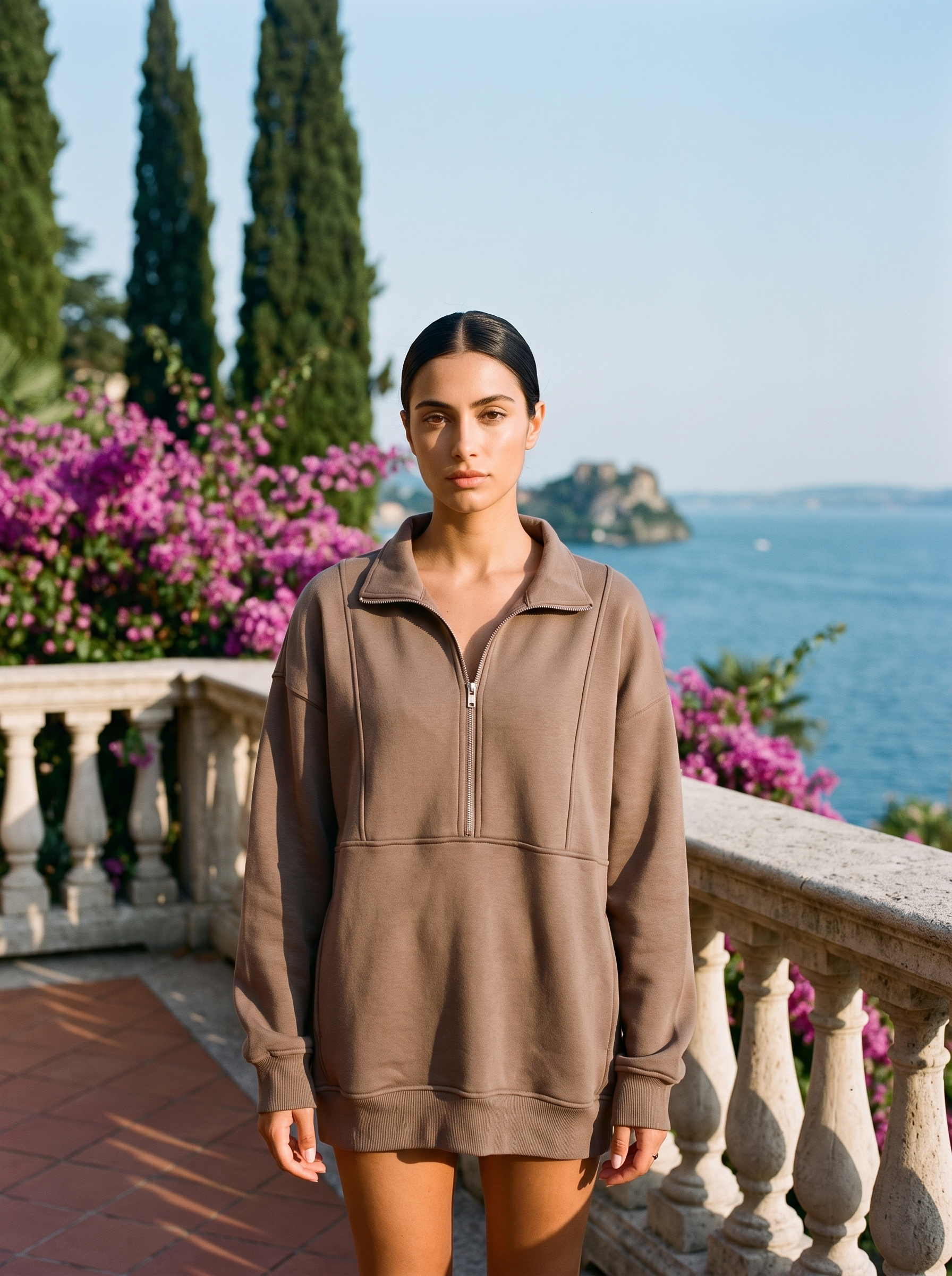 Woman wearing a coffee brown oversized half-zip pocket sweatshirt on a Lake Como terrace — Aveloire