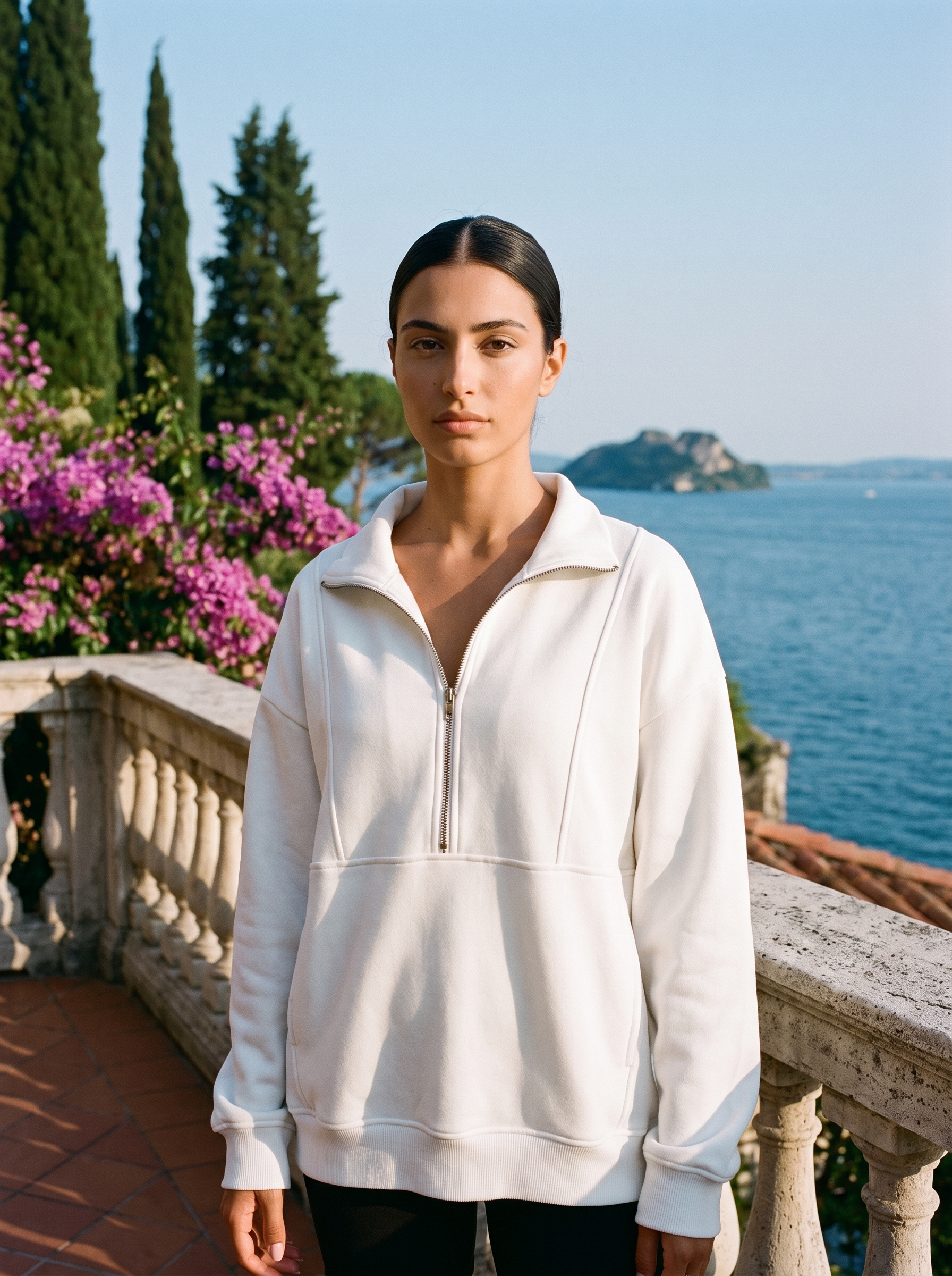 Woman wearing a white oversized half-zip pocket sweatshirt on a Lake Como terrace — Aveloire