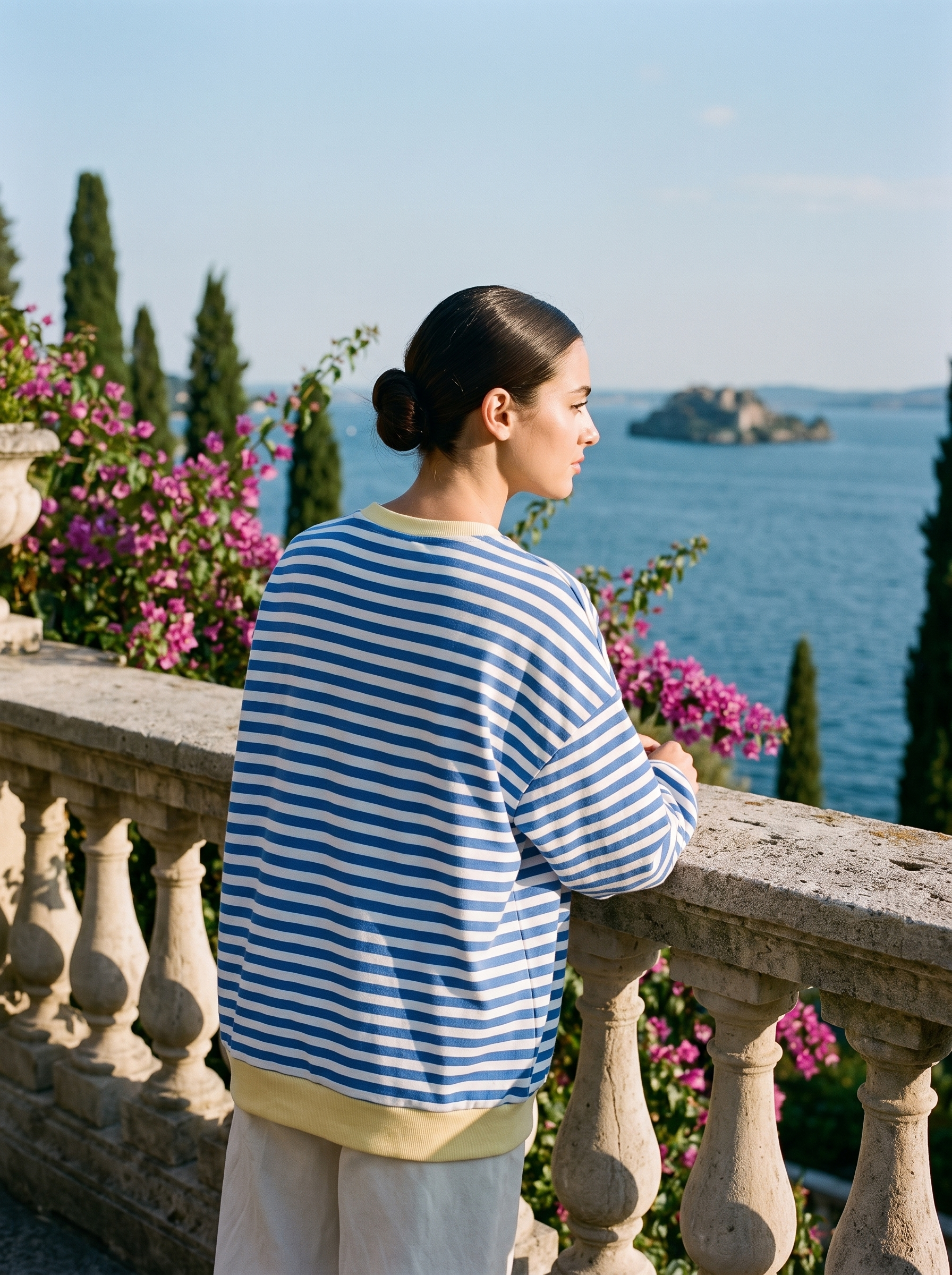 Back view of a blue and white striped oversized sweatshirt on a Lake Como terrace — Aveloire