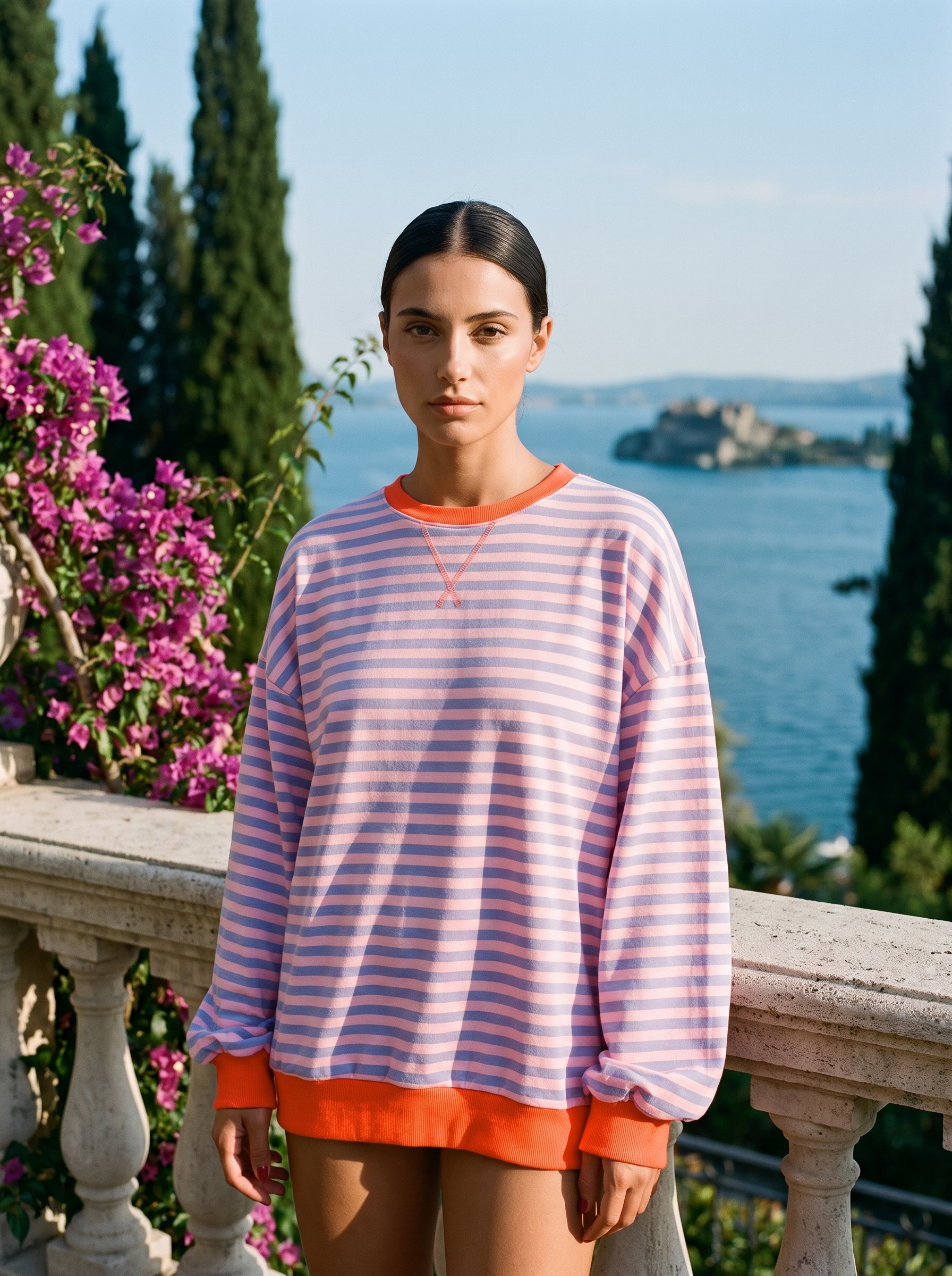 Woman wearing a pink and lilac striped oversized sweatshirt on a Lake Como terrace — Aveloire