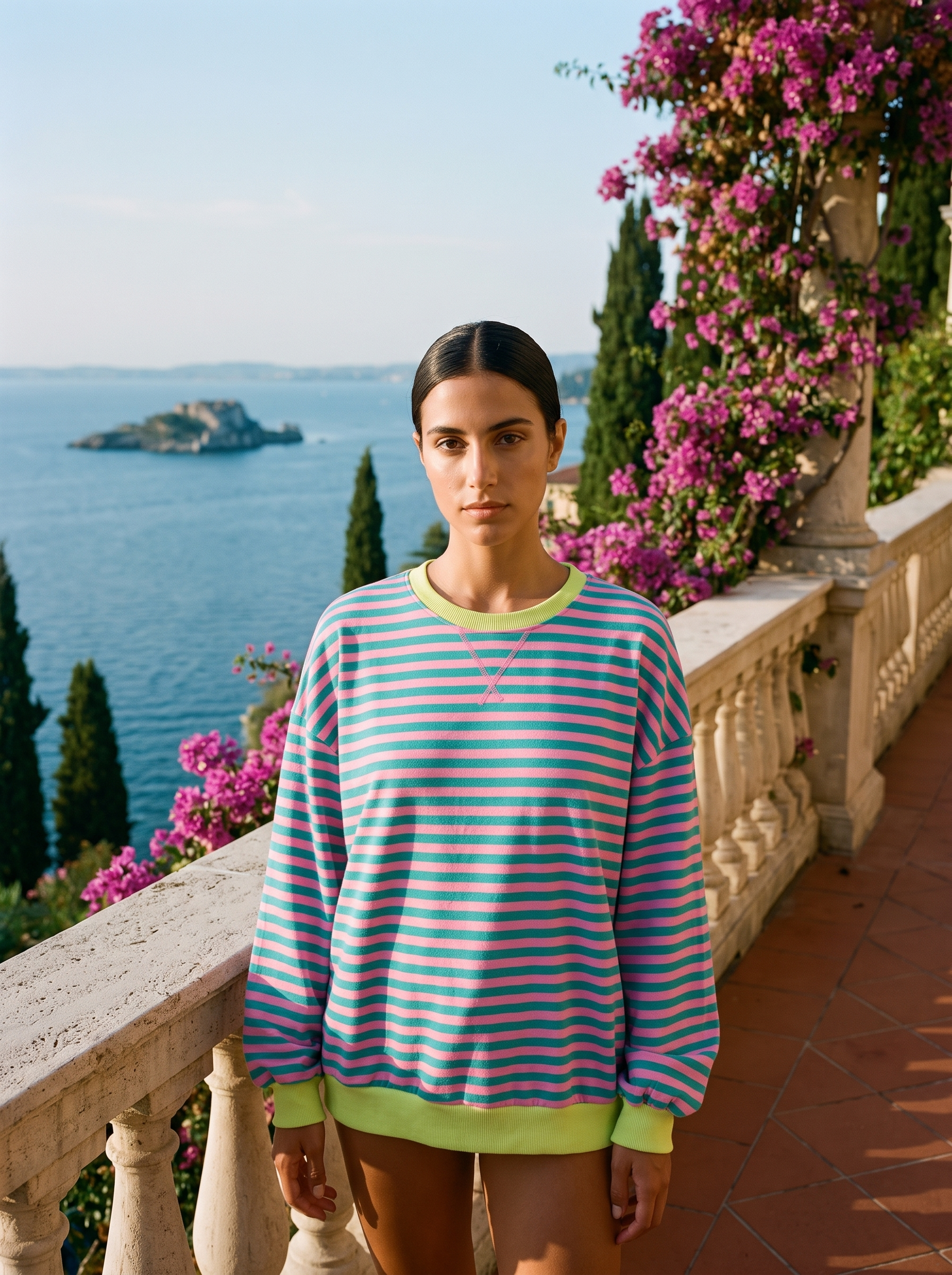 Woman wearing a pink and teal striped oversized sweatshirt on a Lake Como terrace — Aveloire