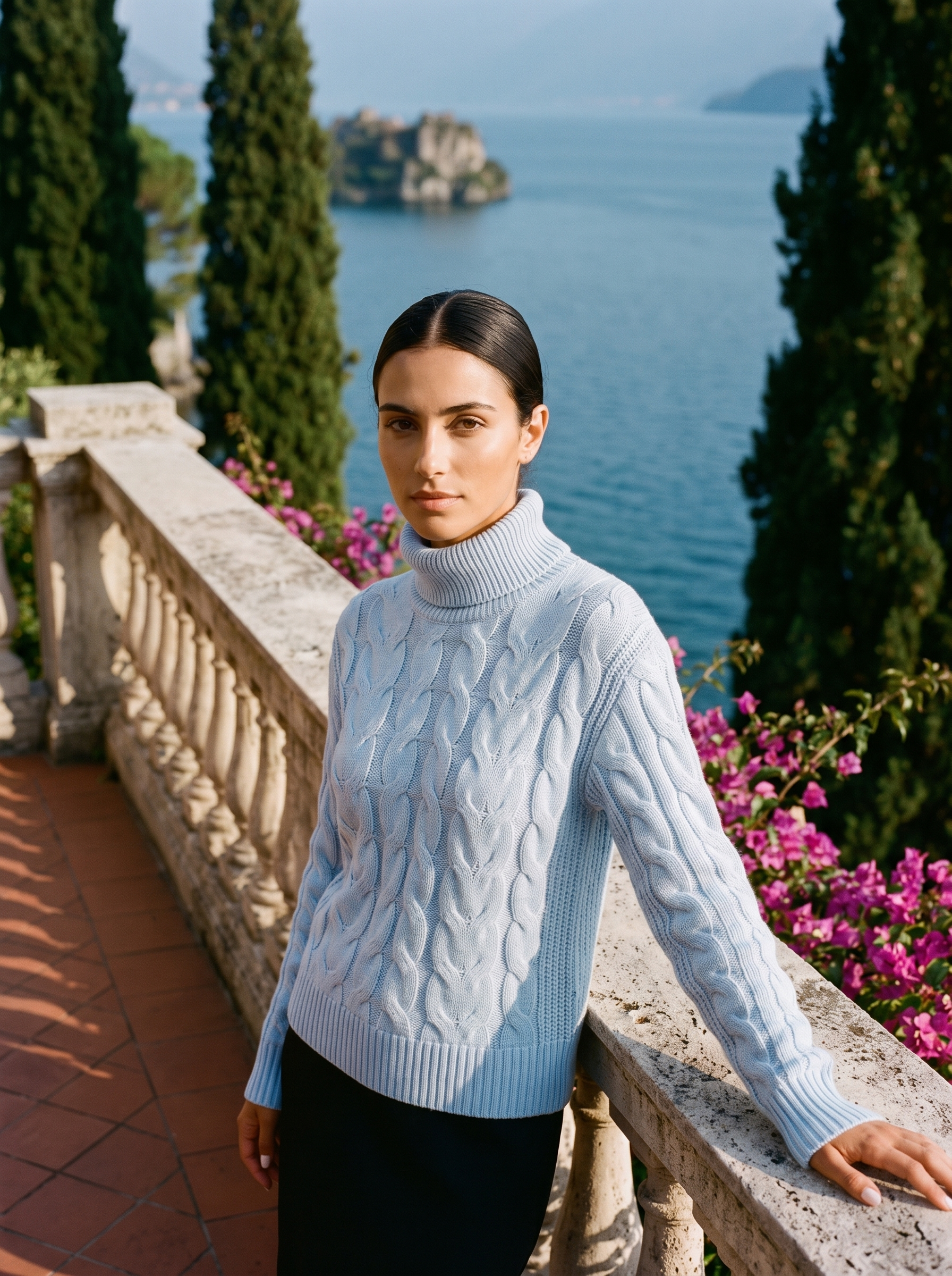 Woman wearing a light blue cable-knit turtleneck sweater on a Lake Como terrace — Aveloire