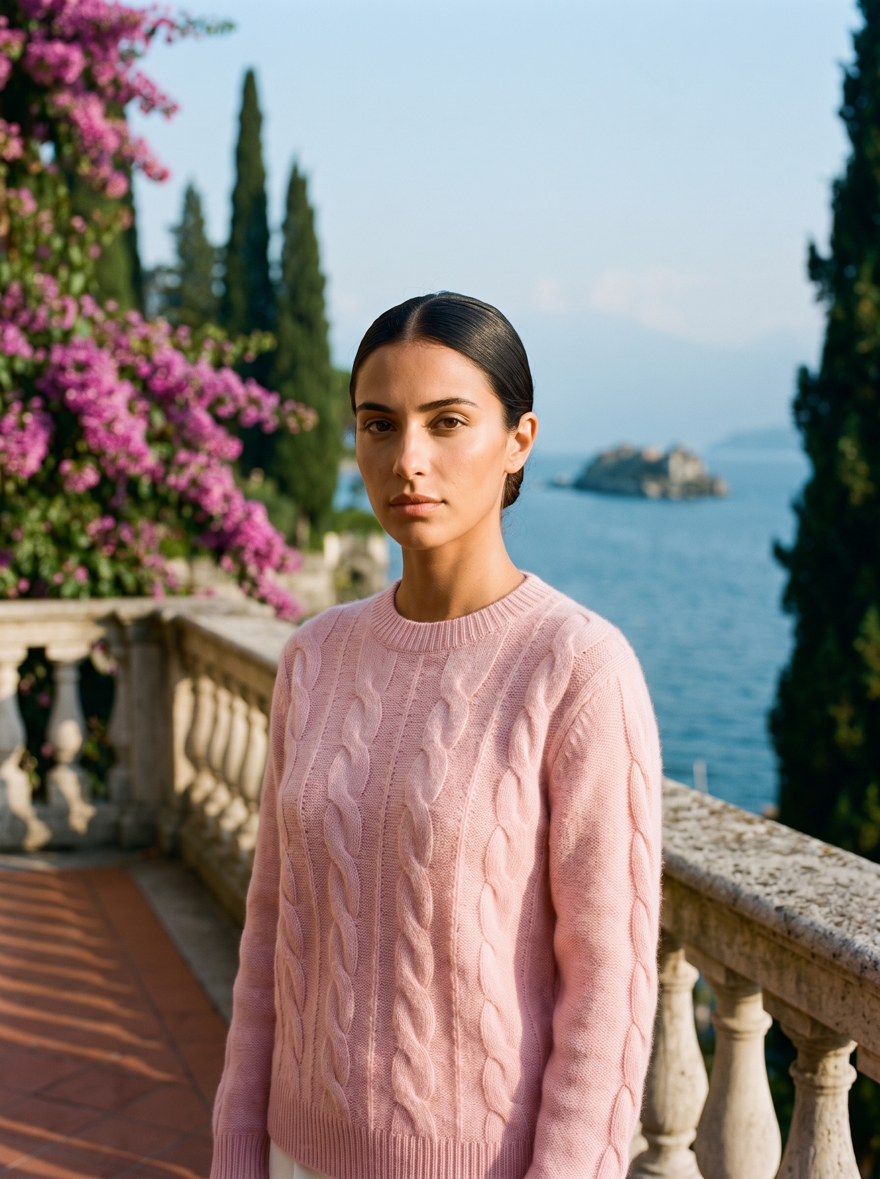 Woman wearing a blush pink cable-knit crew neck sweater on a Lake Como terrace — Aveloire