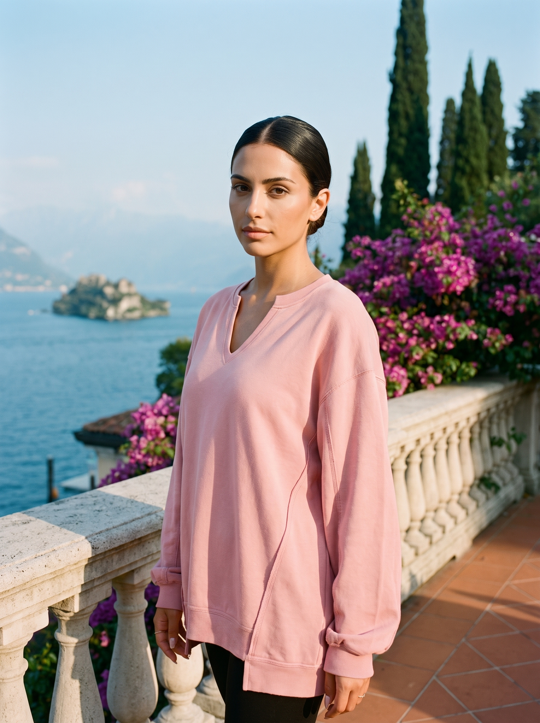 Woman wearing a blush pink V-neck sweatshirt tunic on a Lake Como terrace, old money style — Aveloire