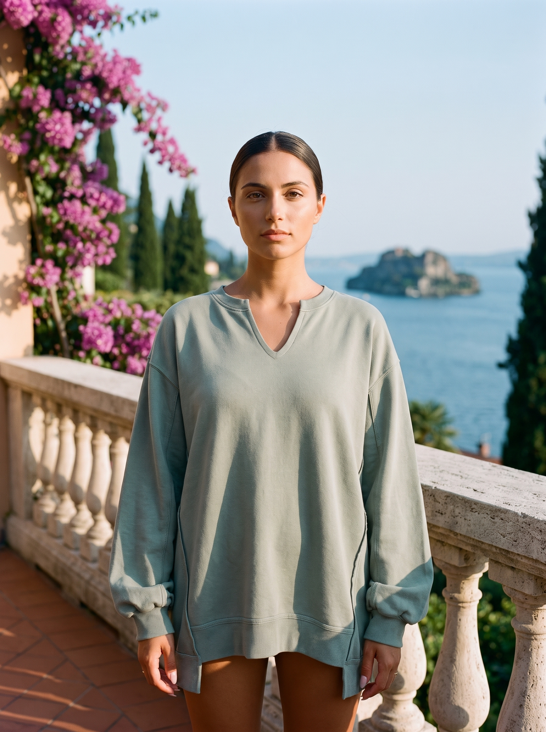 Woman wearing a sage green V-neck sweatshirt tunic on a Lake Como terrace, old money style — Aveloire