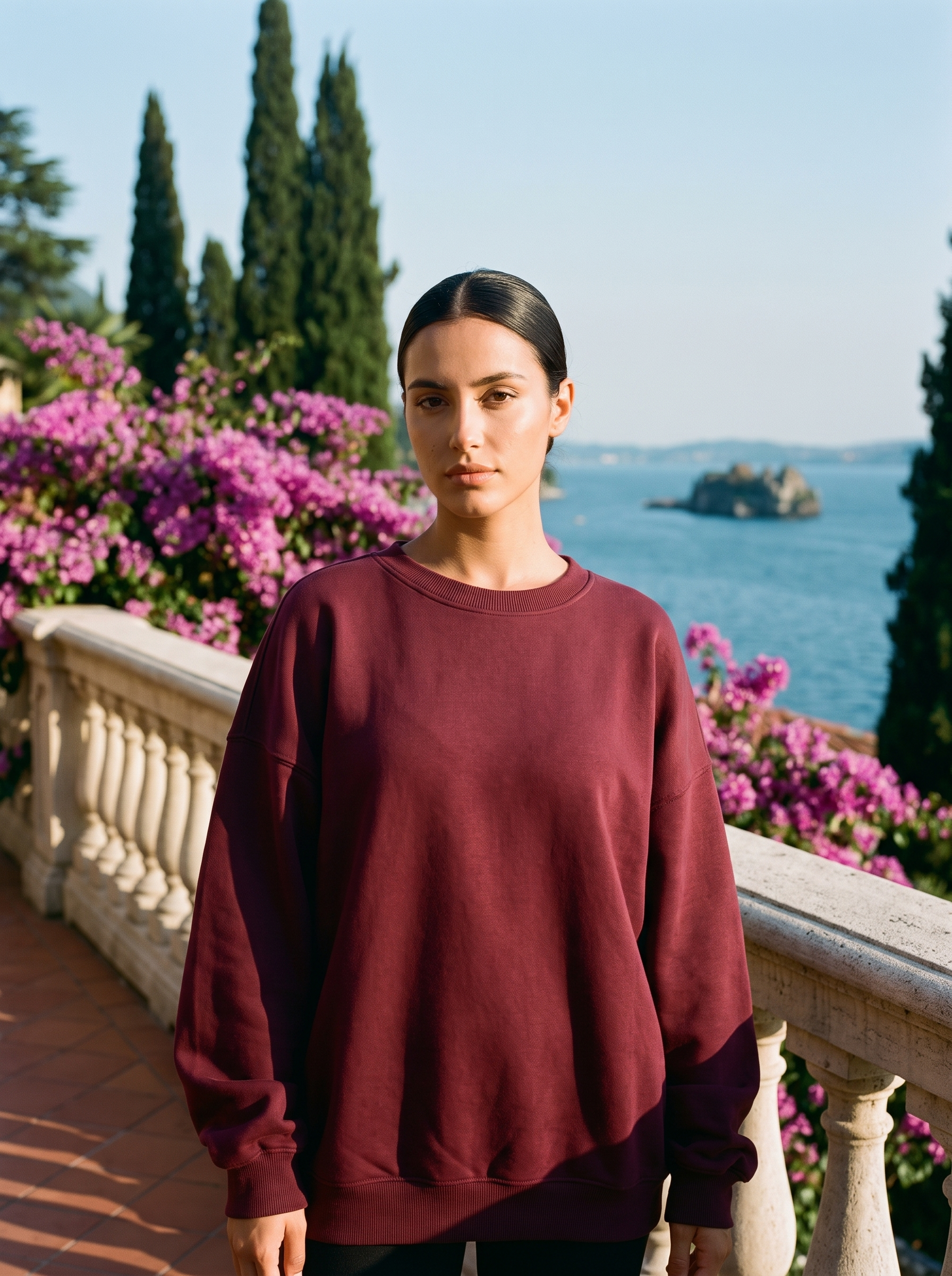 Woman wearing a burgundy oversized crew neck sweatshirt on a Lake Como terrace, old money style — Aveloire