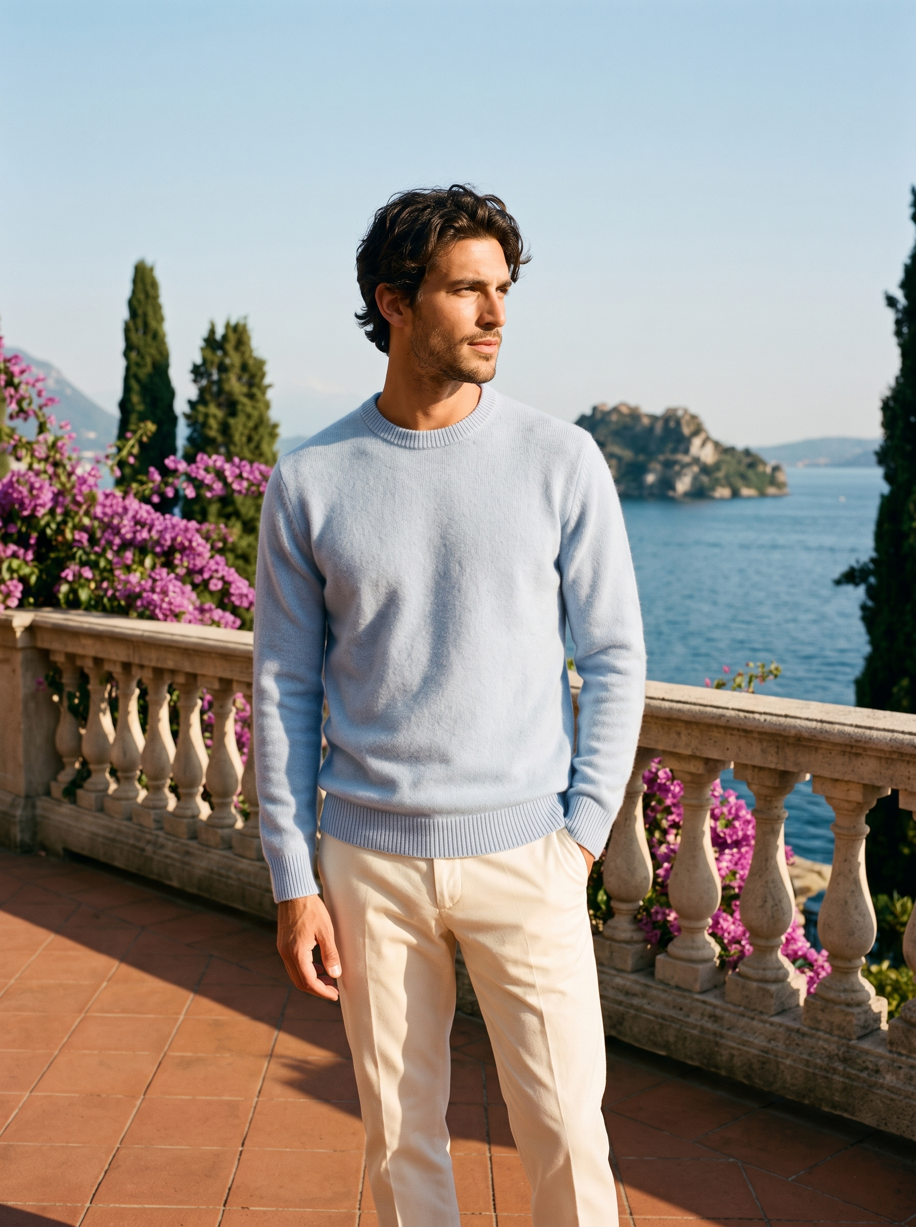 Full body view of a man in a light blue crewneck sweater and cream trousers on a Lake Como terrace — Aveloire