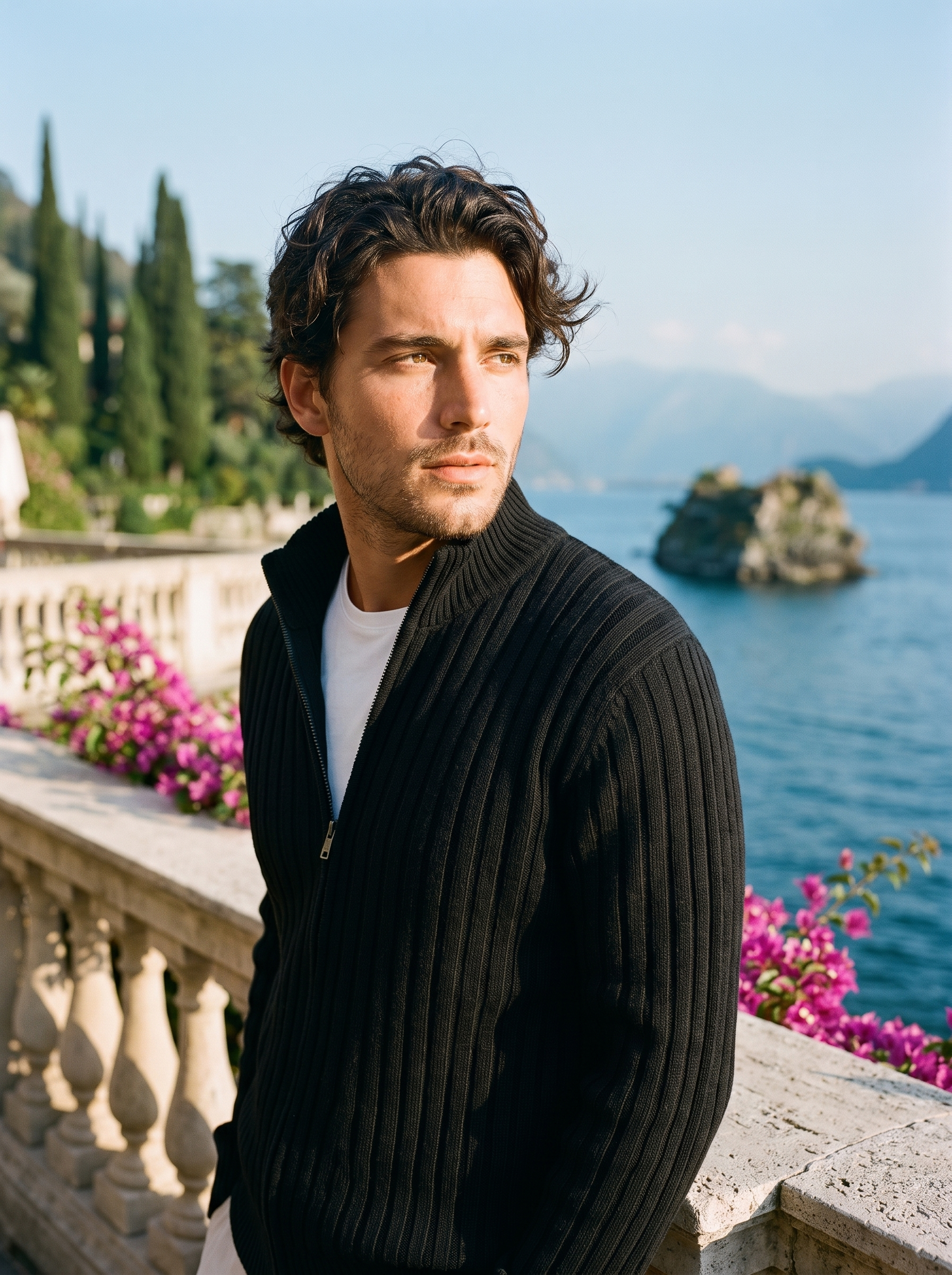 Man wearing a black ribbed cotton full-zip cardigan on a terrace overlooking Lake Como, old money style — Aveloire