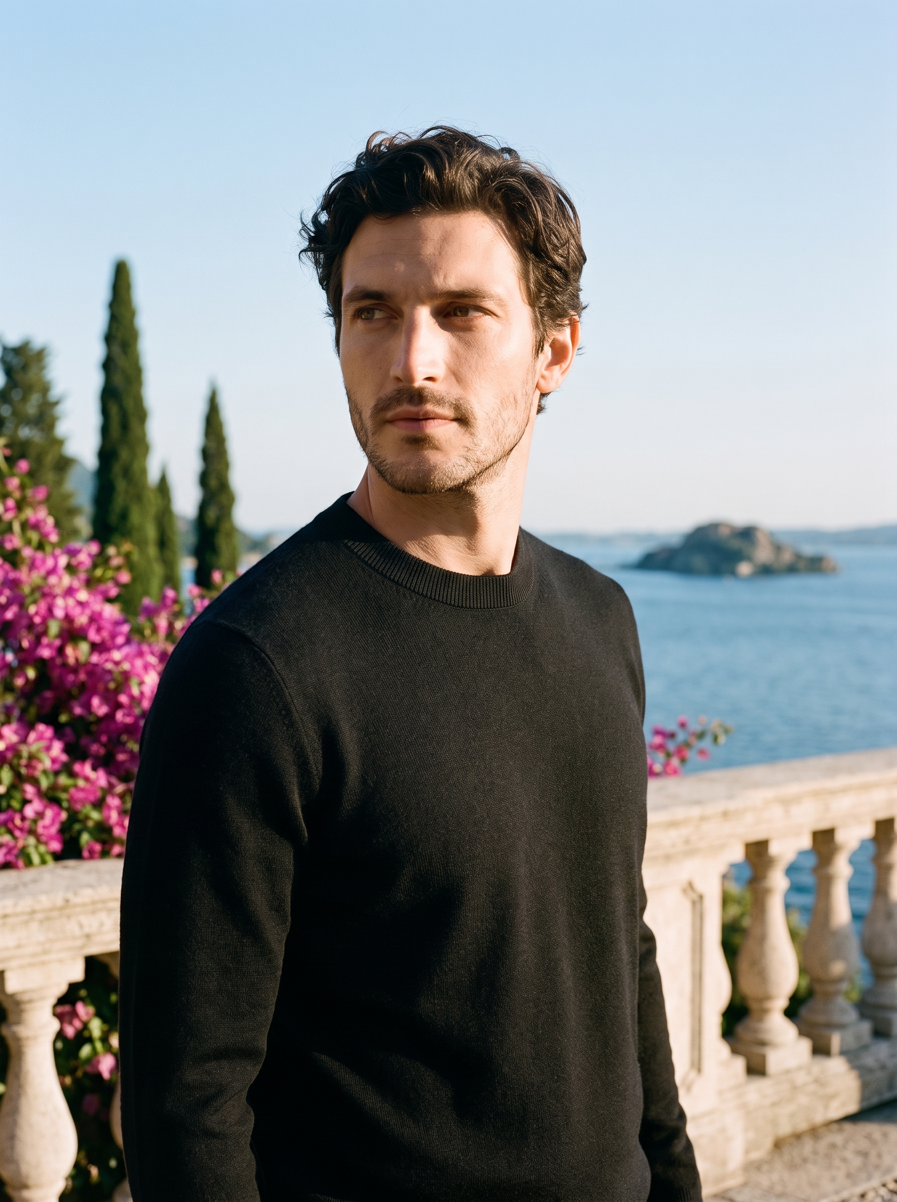 Man wearing a black 100% wool crewneck sweater on a terrace overlooking Lake Como, old money style — Aveloire