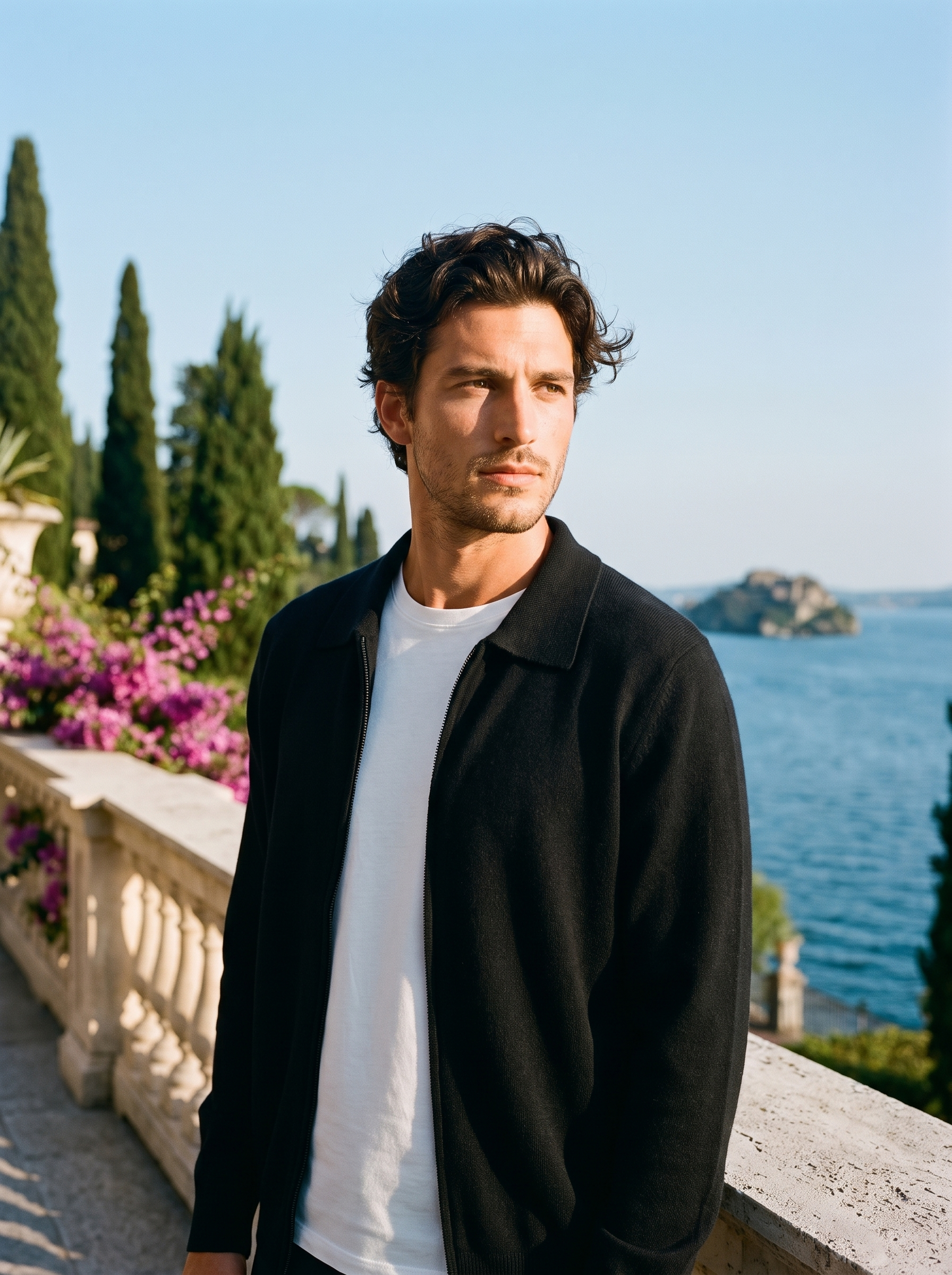 Man wearing a black mercerized wool zip-up collared cardigan on a terrace overlooking Lake Como, old money style — Aveloire