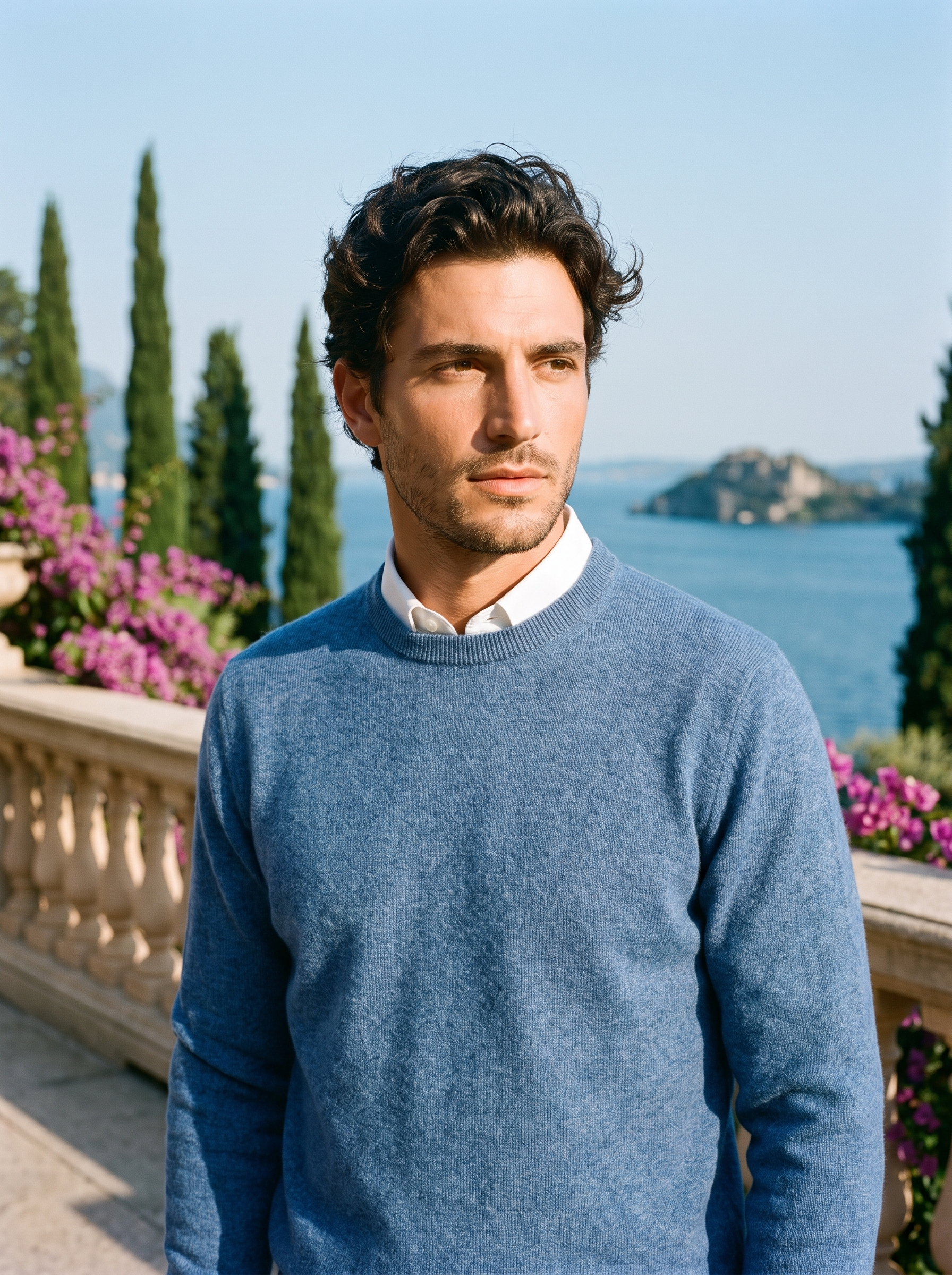 Man wearing a blue melange crewneck sweater on a terrace overlooking Lake Como, old money style — Aveloire