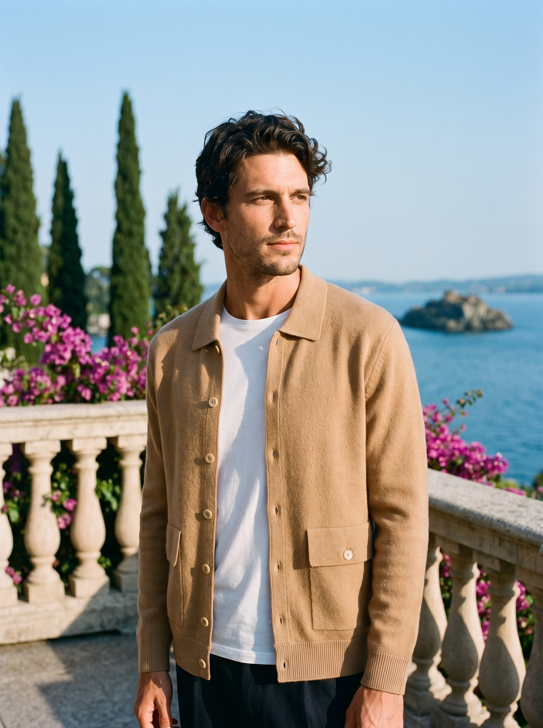 Man wearing a camel 100% cashmere collared cardigan on a terrace overlooking Lake Como, old money style — Aveloire