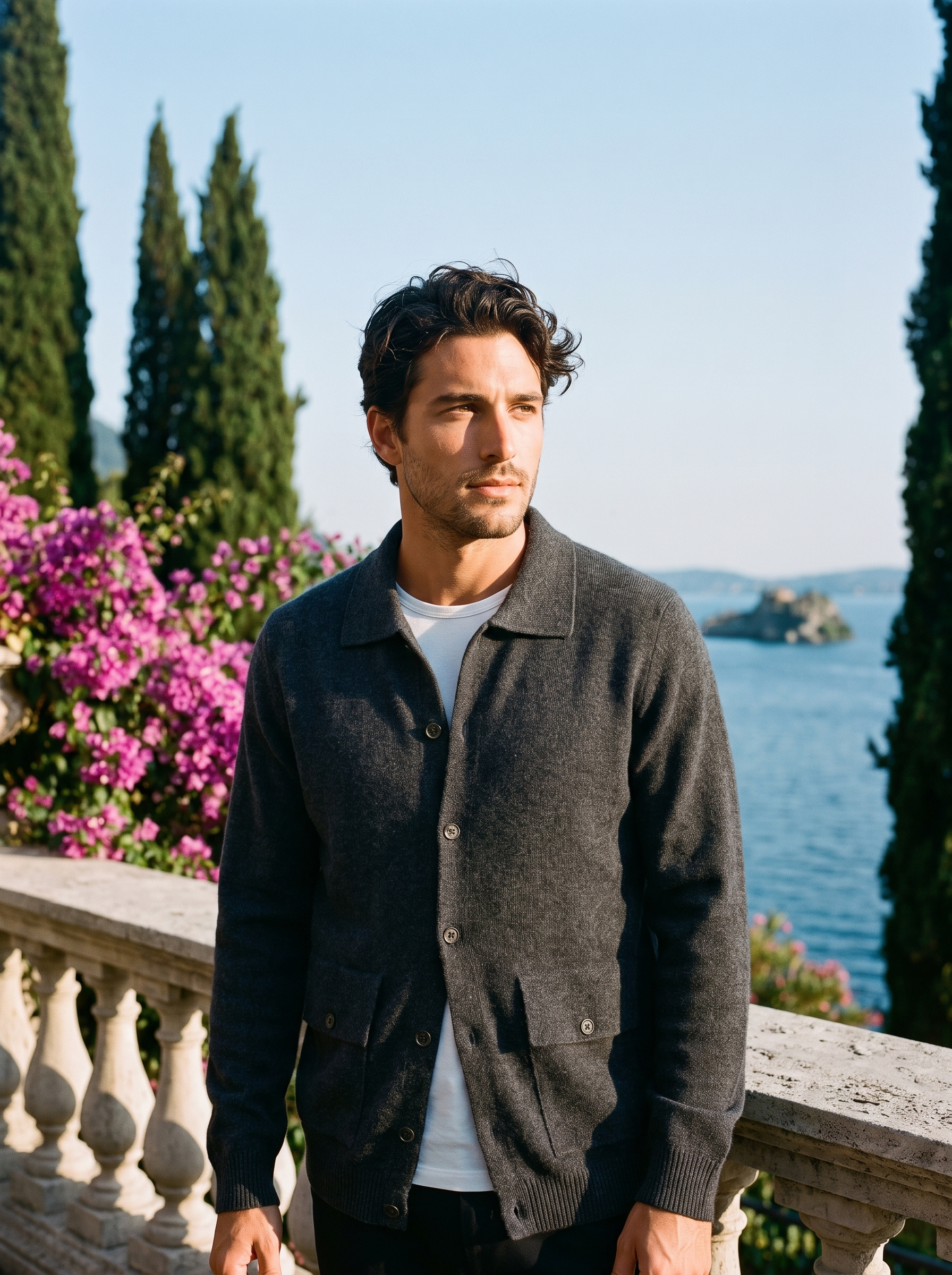 Man wearing a dark gray 100% cashmere collared cardigan on a terrace overlooking Lake Como, old money style — Aveloire