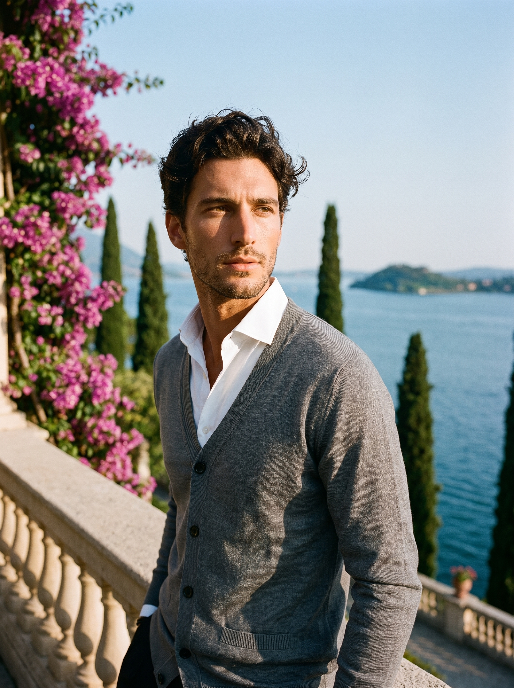 Man wearing a gray V-neck button cardigan on a terrace overlooking Lake Como, old money style — Aveloire