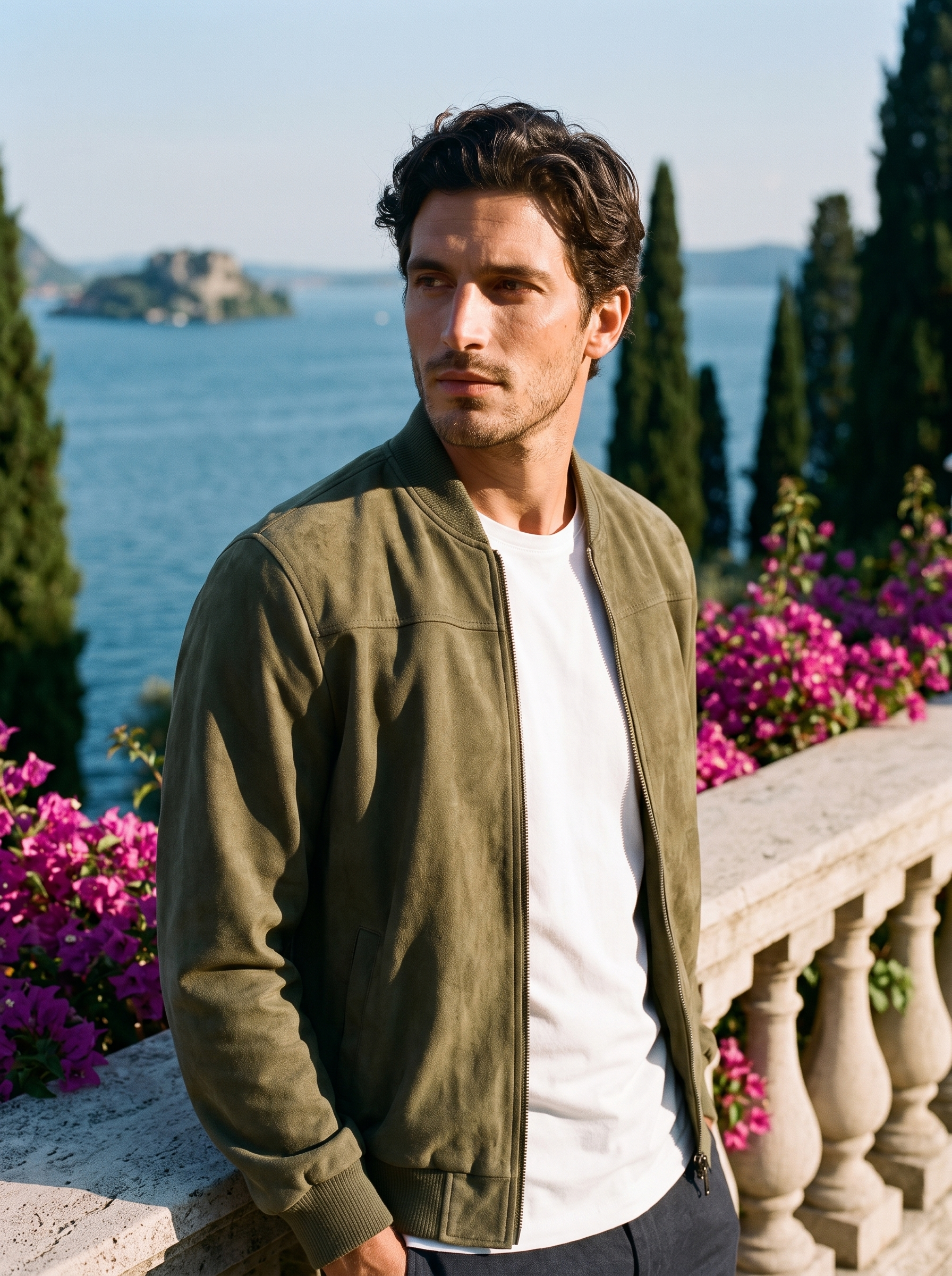 Man wearing a green suede zip jacket on a terrace overlooking Lake Como, old money style — Aveloire
