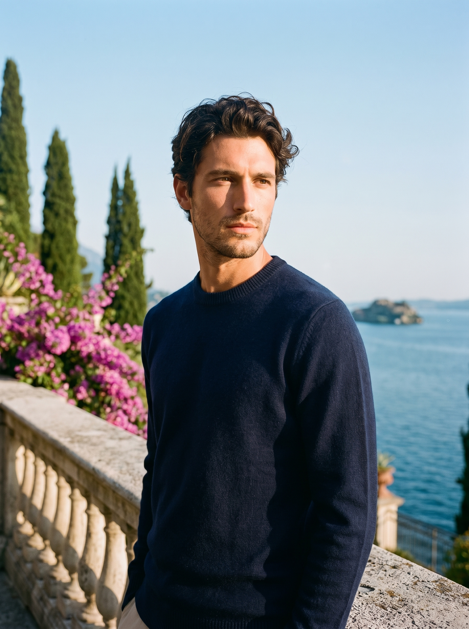 Man wearing a navy classic crewneck sweater on a terrace overlooking Lake Como, old money style — Aveloire