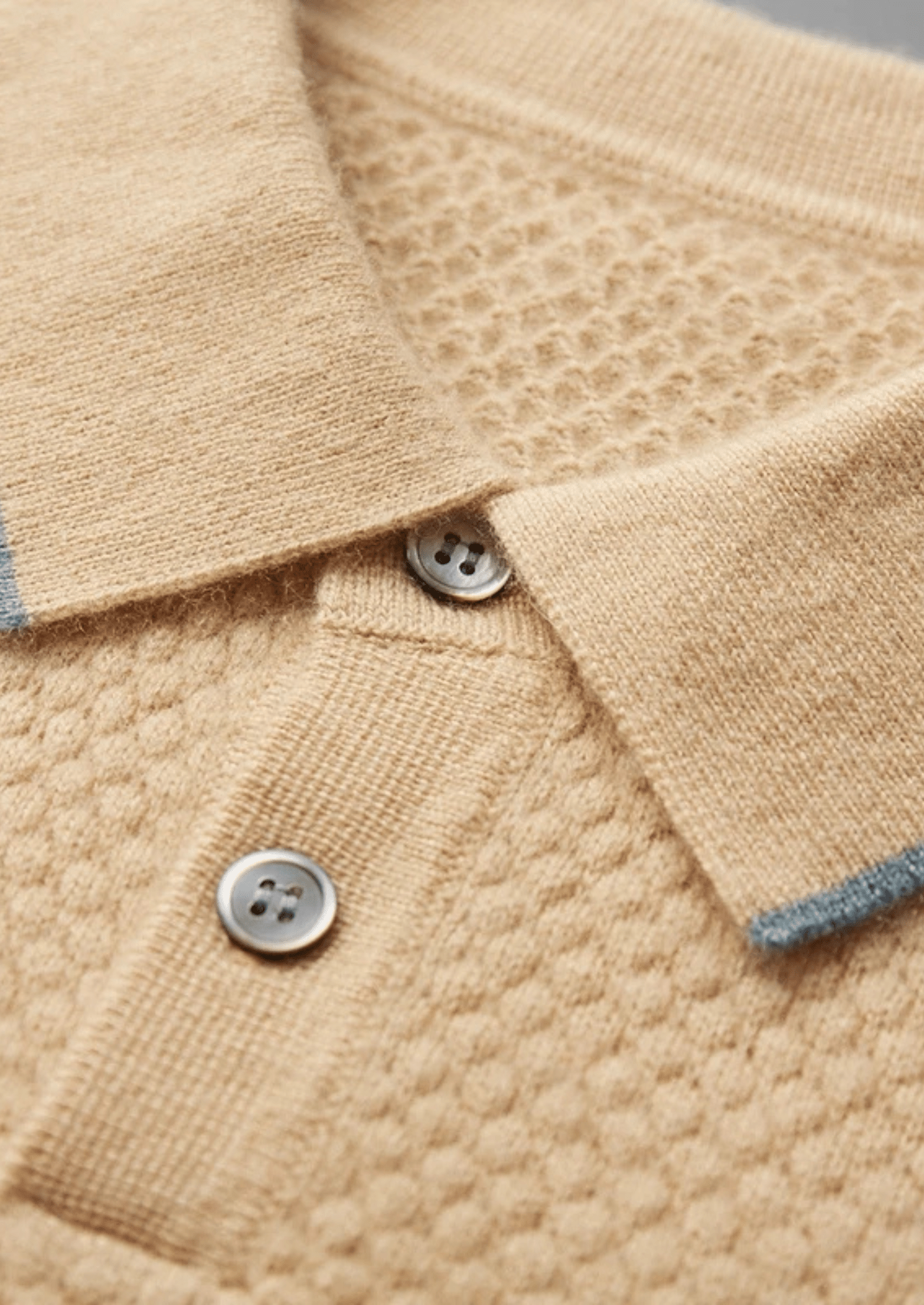 Close-up of a beige textured fabric with buttons