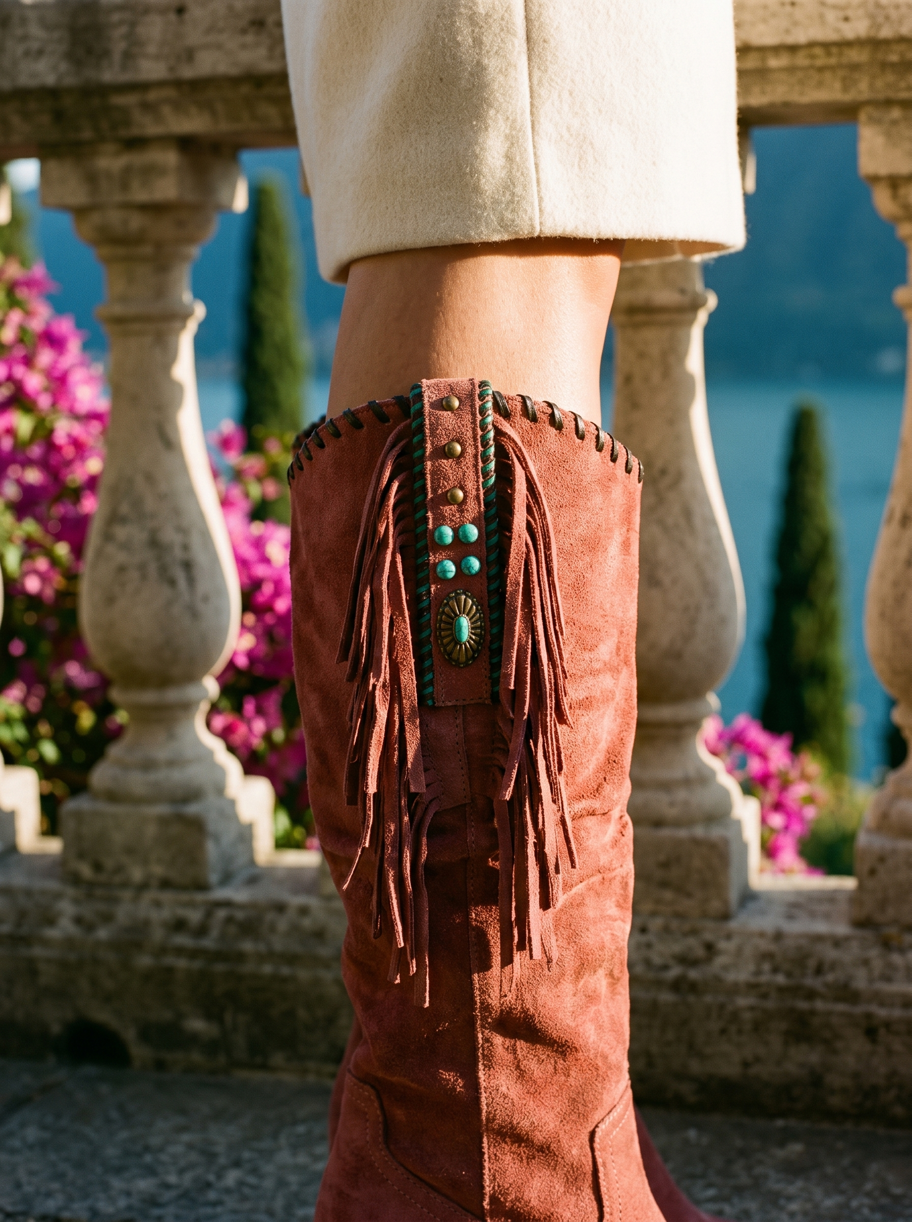 Detail of the turquoise beaded panel and suede fringe on a red western knee high boot — Aveloire