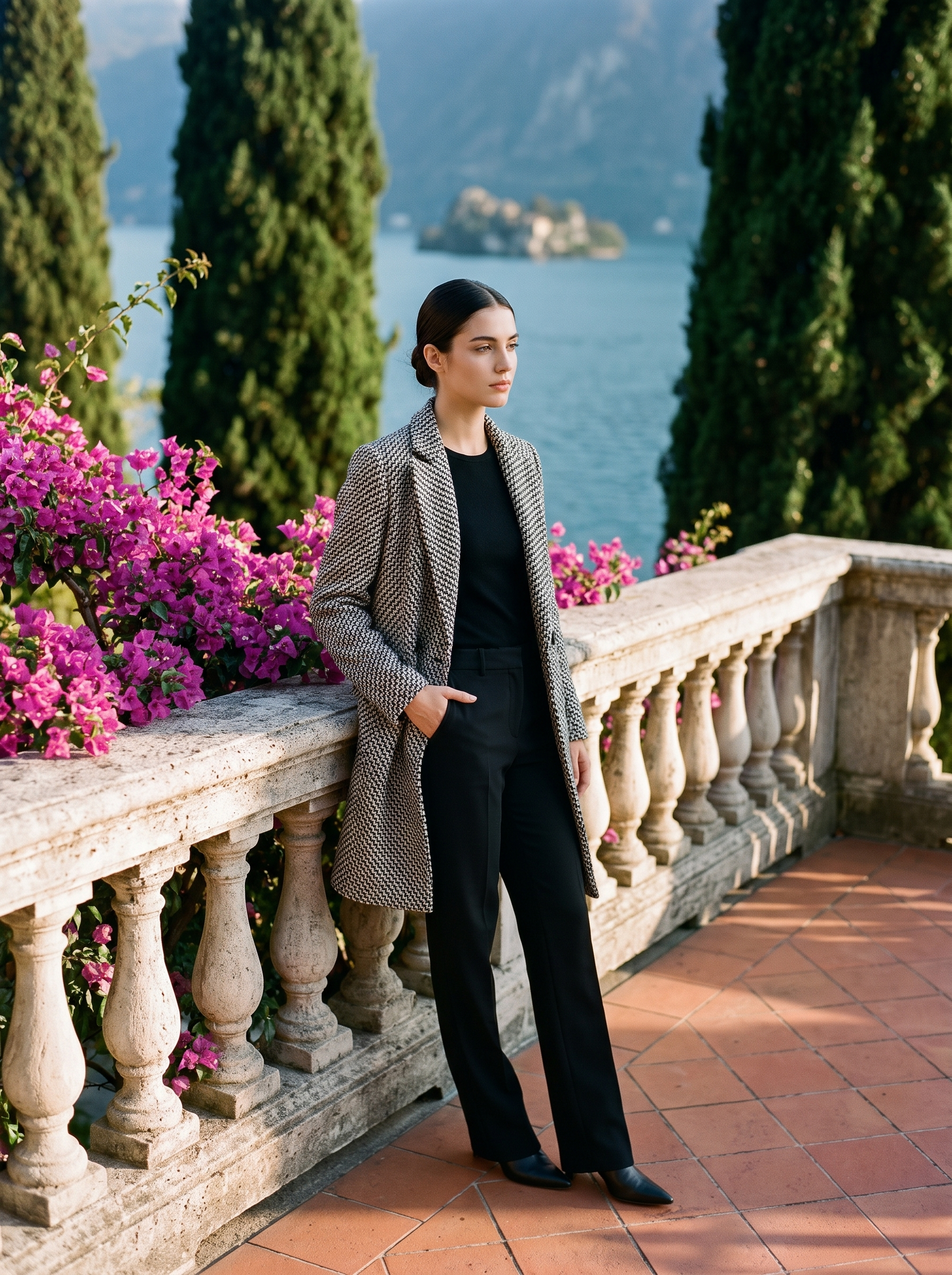 Full-length front view of a black-and-white tweed wool coat on a Lake Como terrace — Aveloire