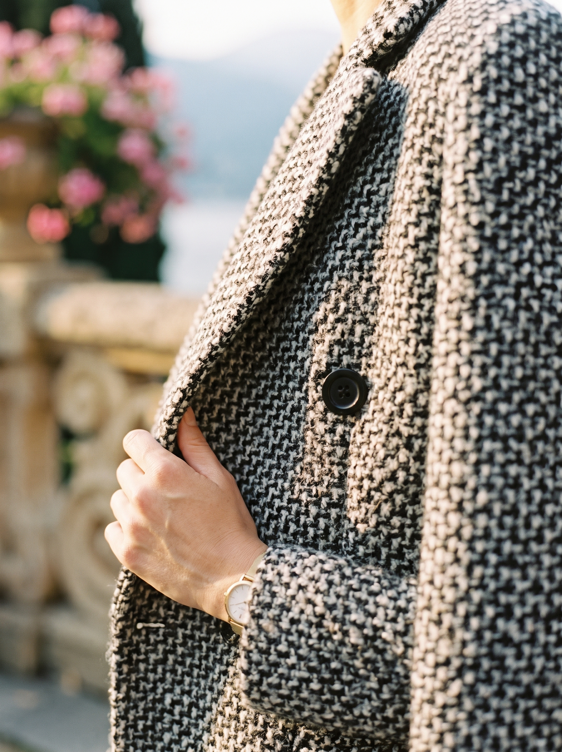 Close-up of the salt-and-pepper tweed weave and lapel on a wool coat — Aveloire