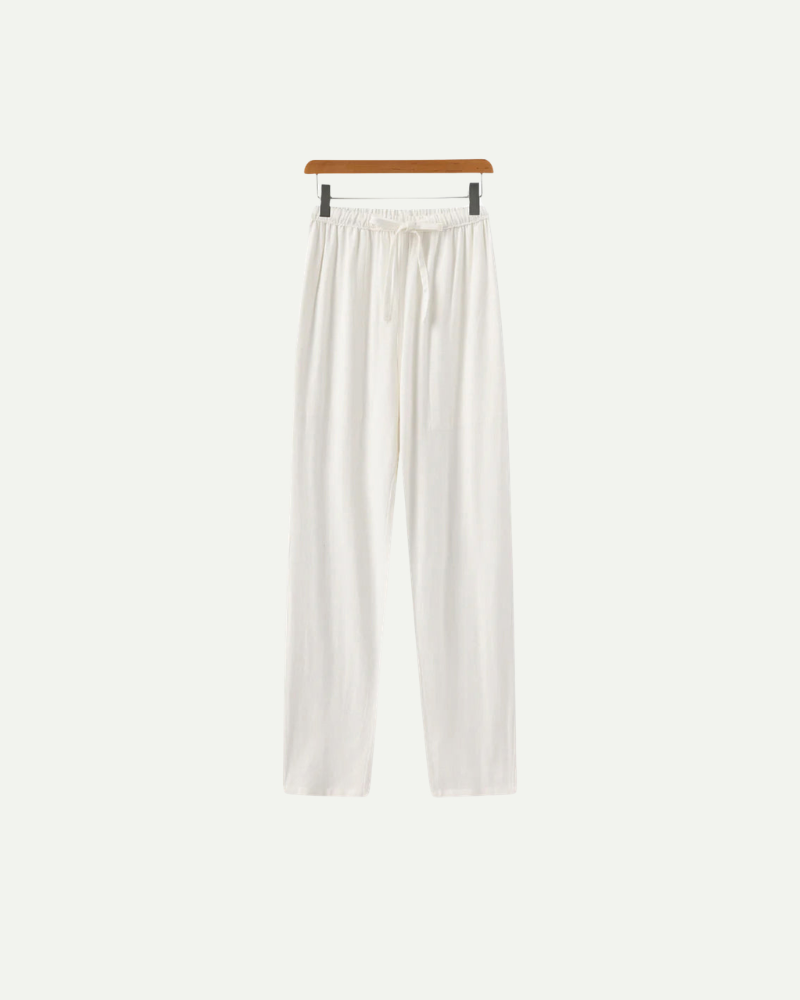 White linen pants on a hanger against a white background