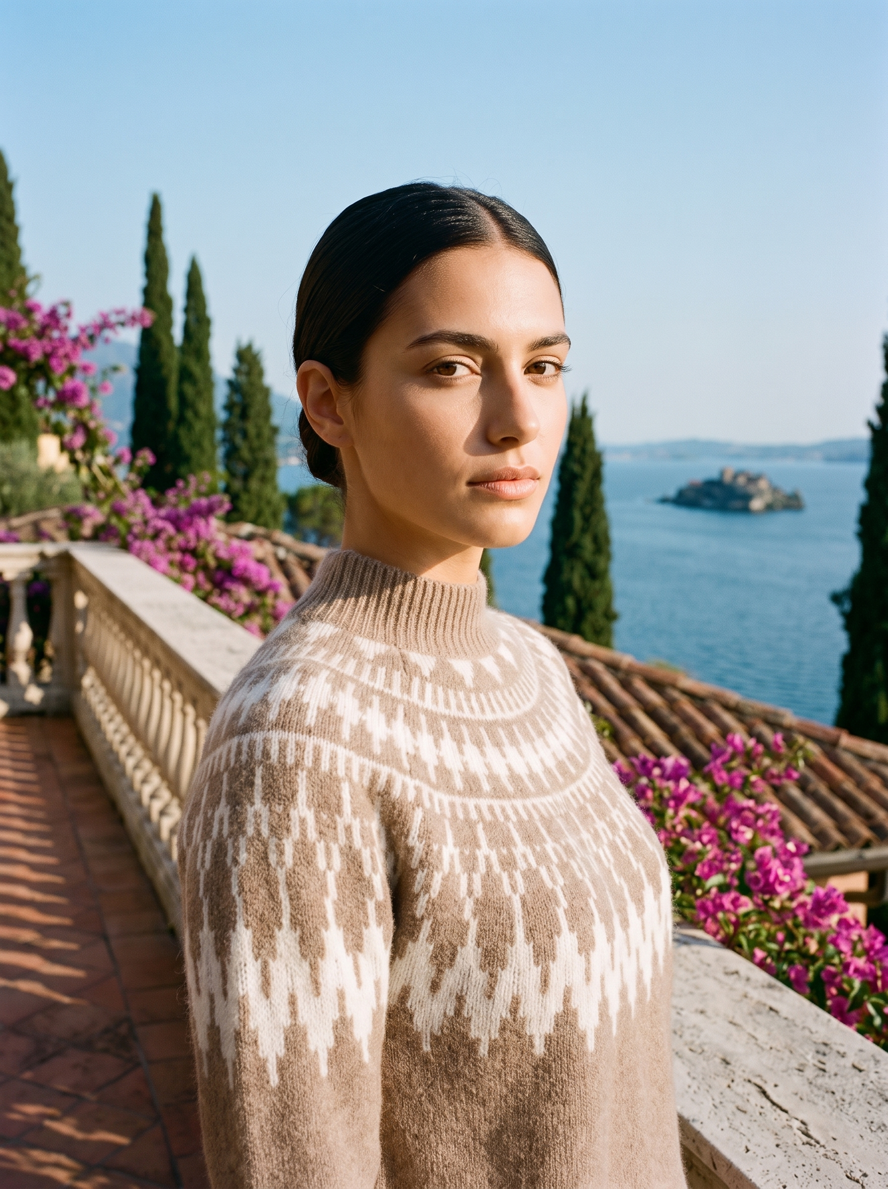 Woman wearing a taupe-beige Fair Isle mock-neck jumper on a terrace overlooking Lake Como — Aveloire