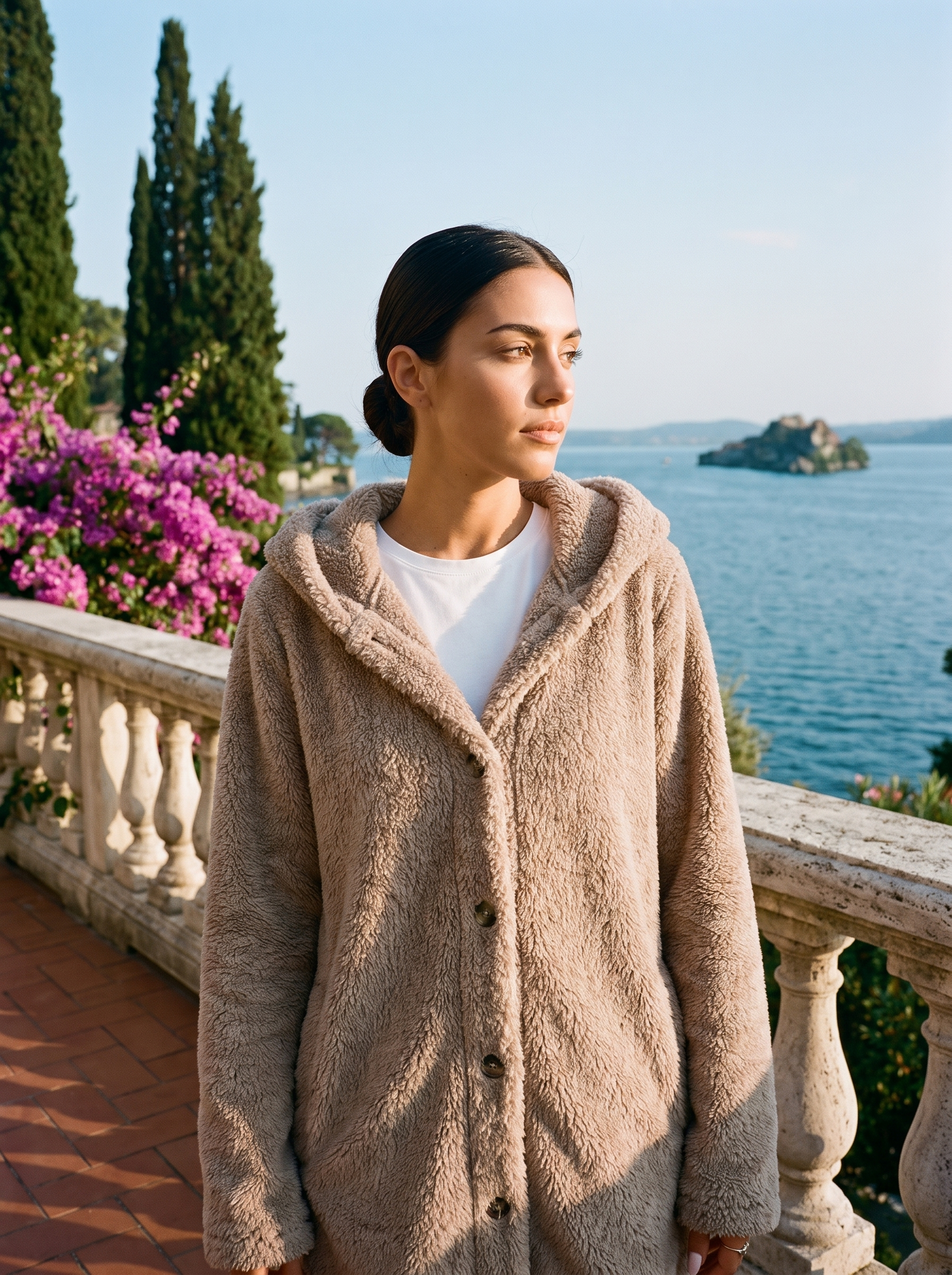 Woman wearing a beige hooded cardigan on a terrace overlooking Lake Como, old money style — Aveloire