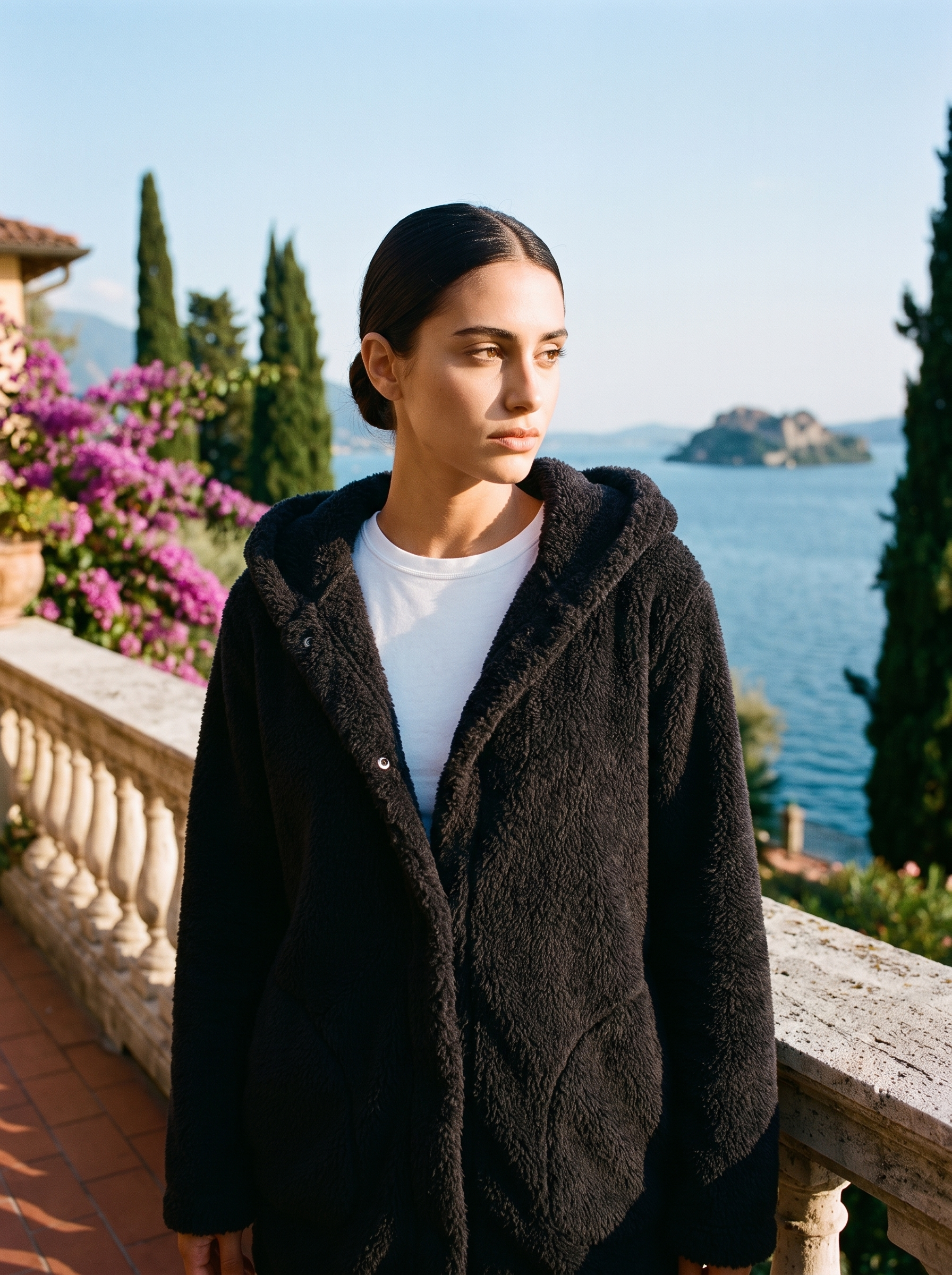 Woman wearing a black hooded cardigan on a terrace overlooking Lake Como, old money style — Aveloire