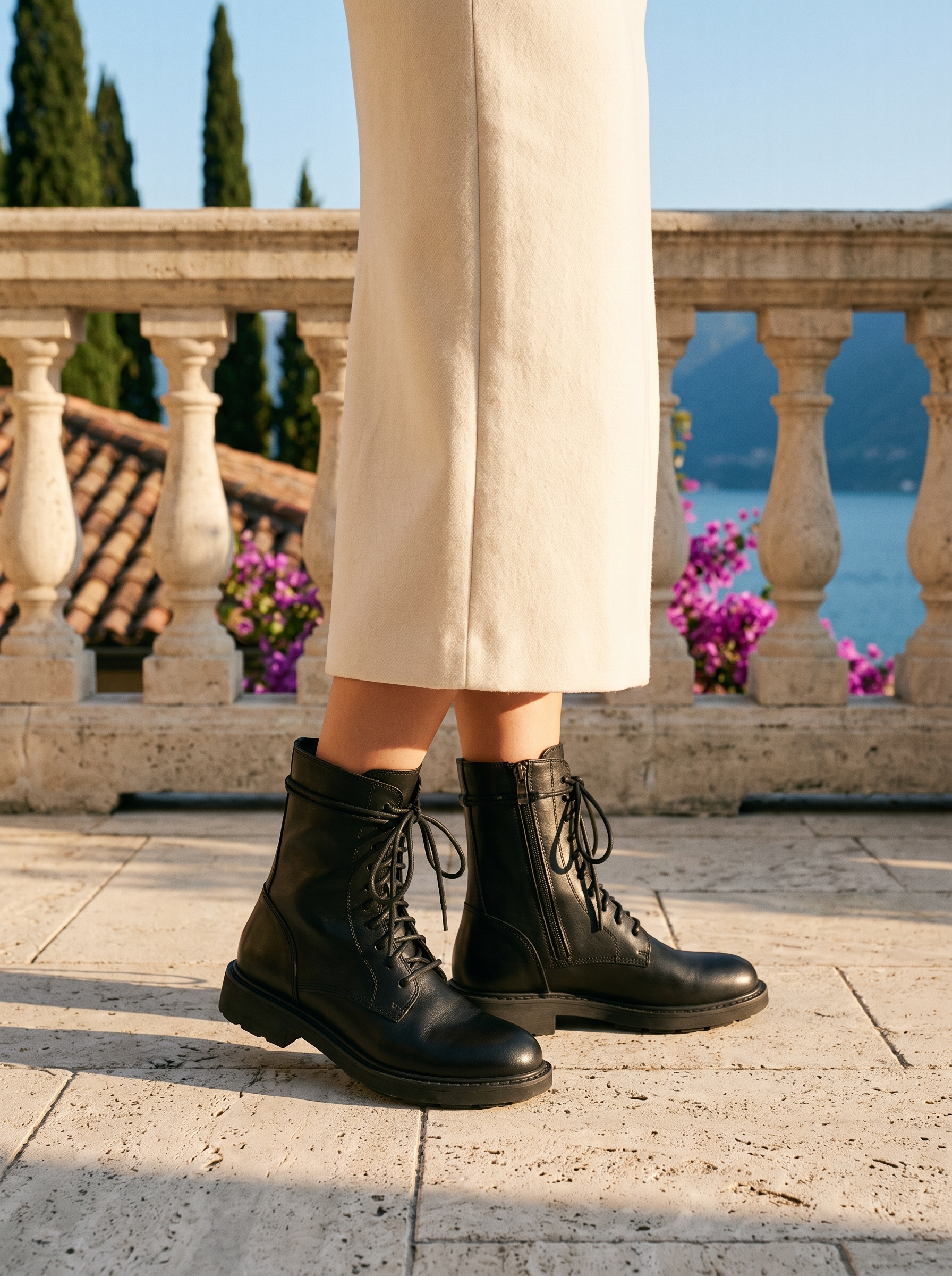Woman wearing black lace-up combat ankle boots on a terrace overlooking Lake Como, old money style — Aveloire