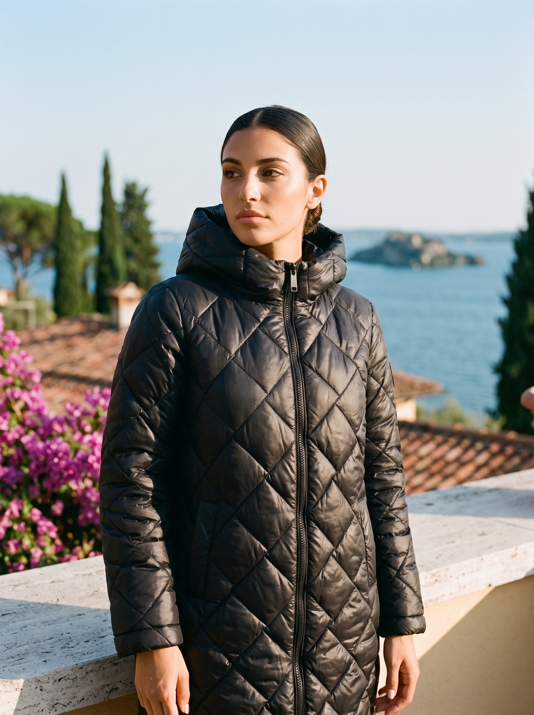 Woman wearing black quilted coat on a Lake Como terrace — Aveloire