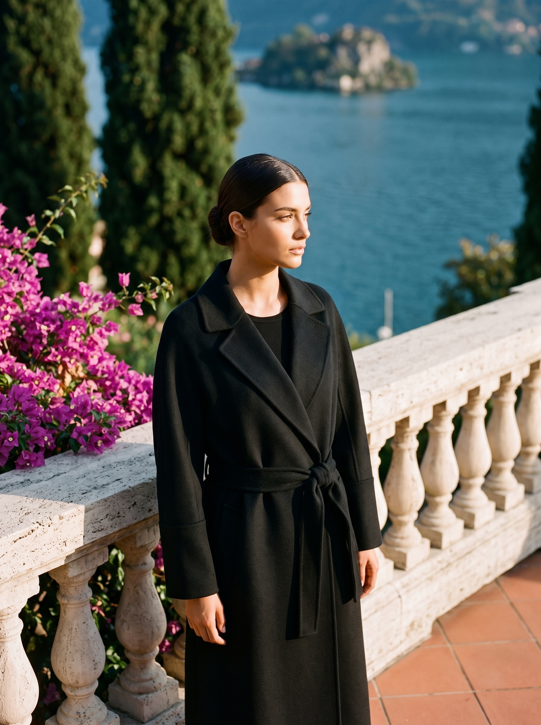 Woman wearing a black belted wool wrap coat on a Lake Como terrace — Aveloire