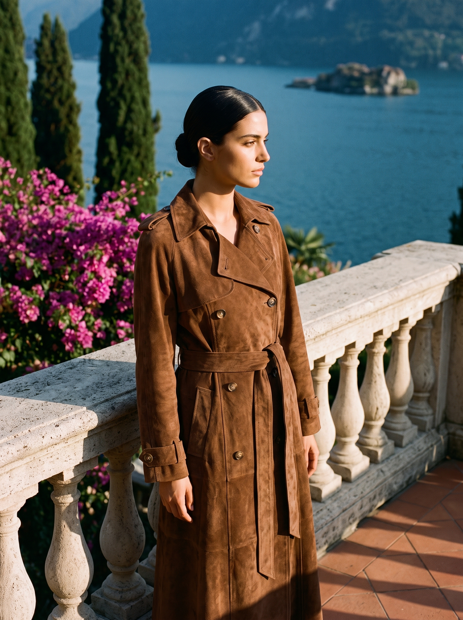 Woman wearing a tobacco-brown suede trench coat on a Lake Como terrace — Aveloire