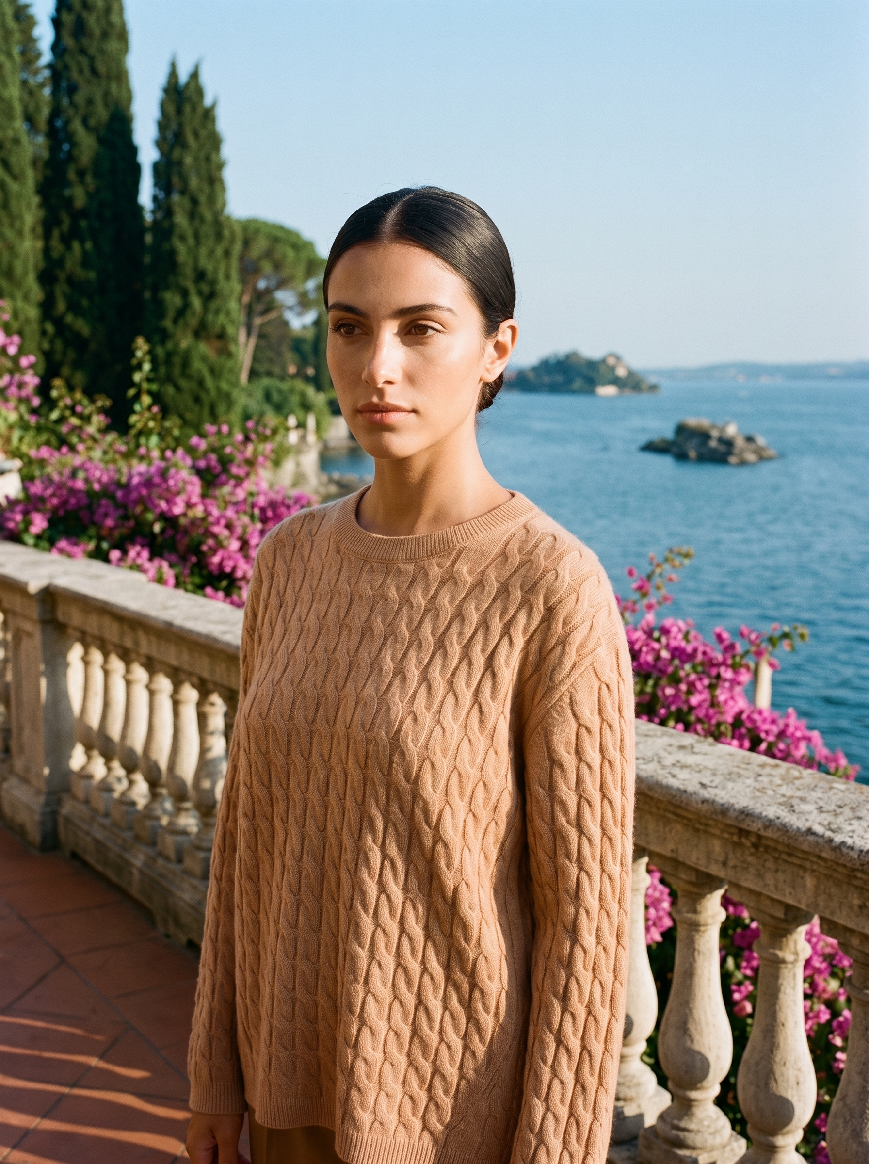 Woman wearing a camel cable-knit jumper on a terrace overlooking Lake Como — Aveloire